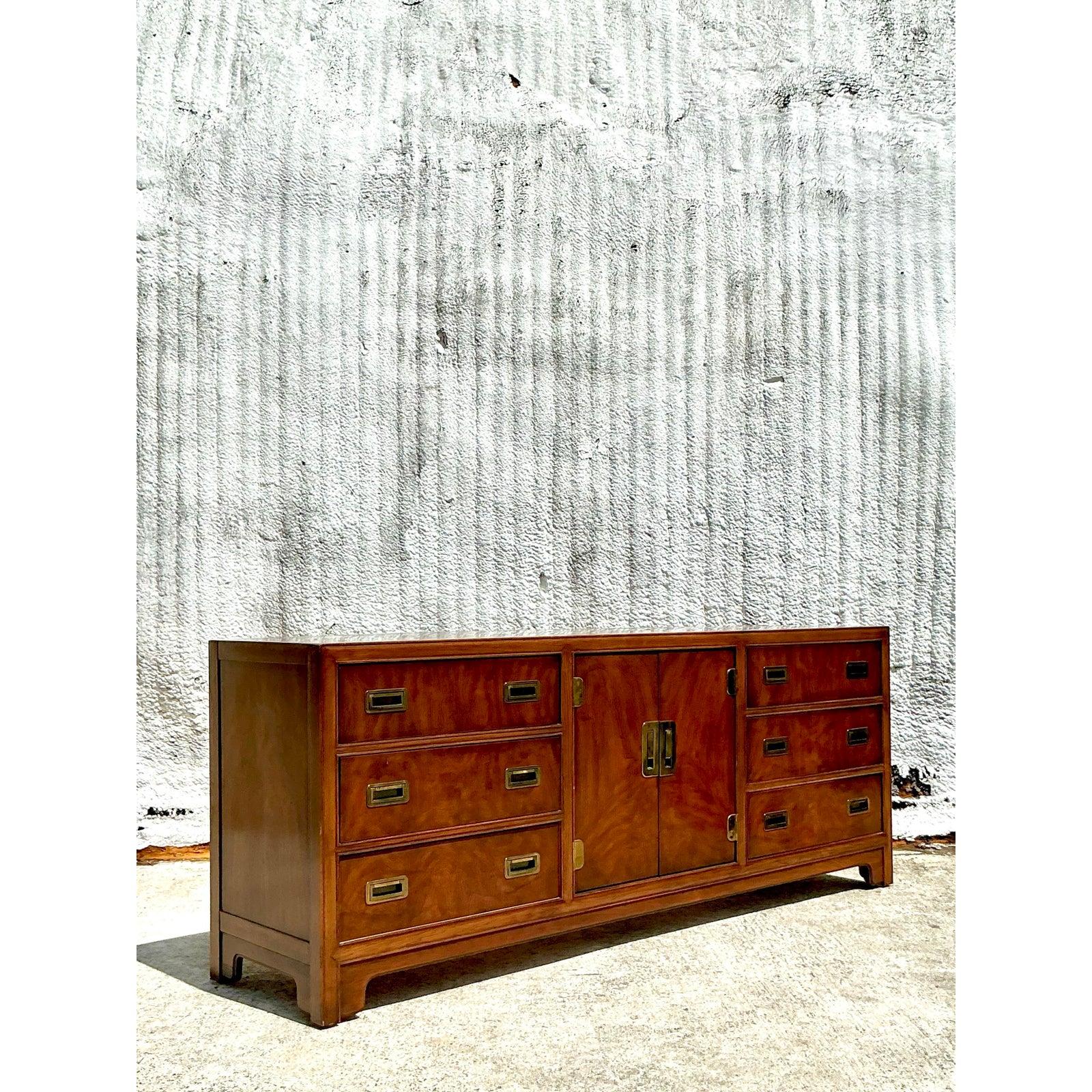 Command attention in any room with this stunning Vintage Boho Drexel Campaign Credenza, a sophisticated fusion of classic American craftsmanship and global design inspiration. Featuring a rich wood grain finish and striking brass recessed