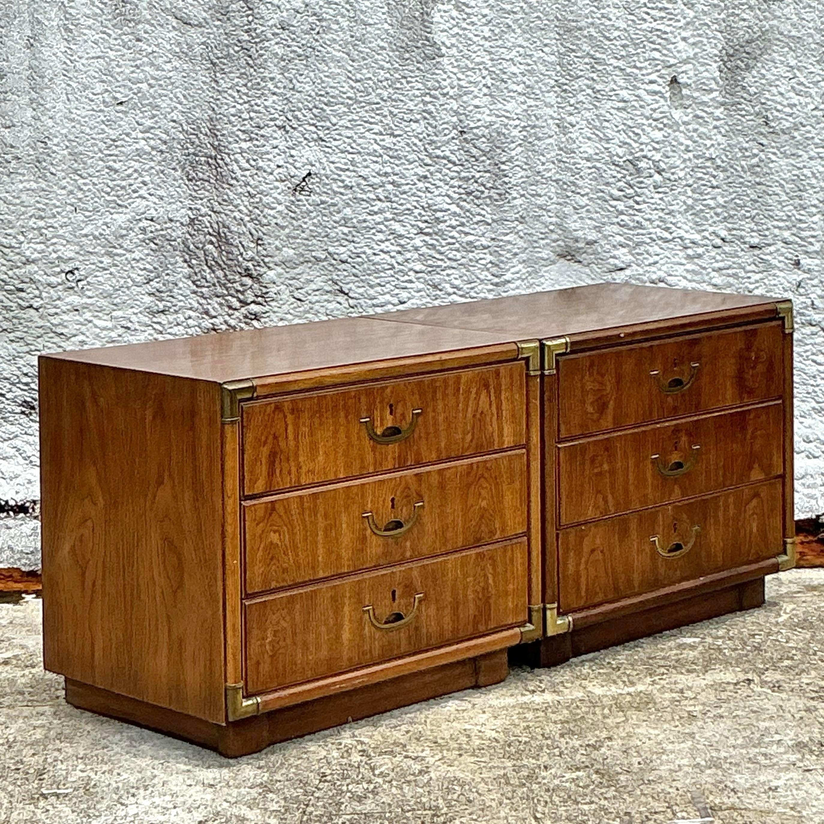 Enhance your bedroom with the sophisticated charm of these Vintage Boho Drexel Campaign Nightstands. Perfect for American-style interiors, these nightstands feature the classic Campaign-style brass hardware combined with a Boho flair. Their sturdy