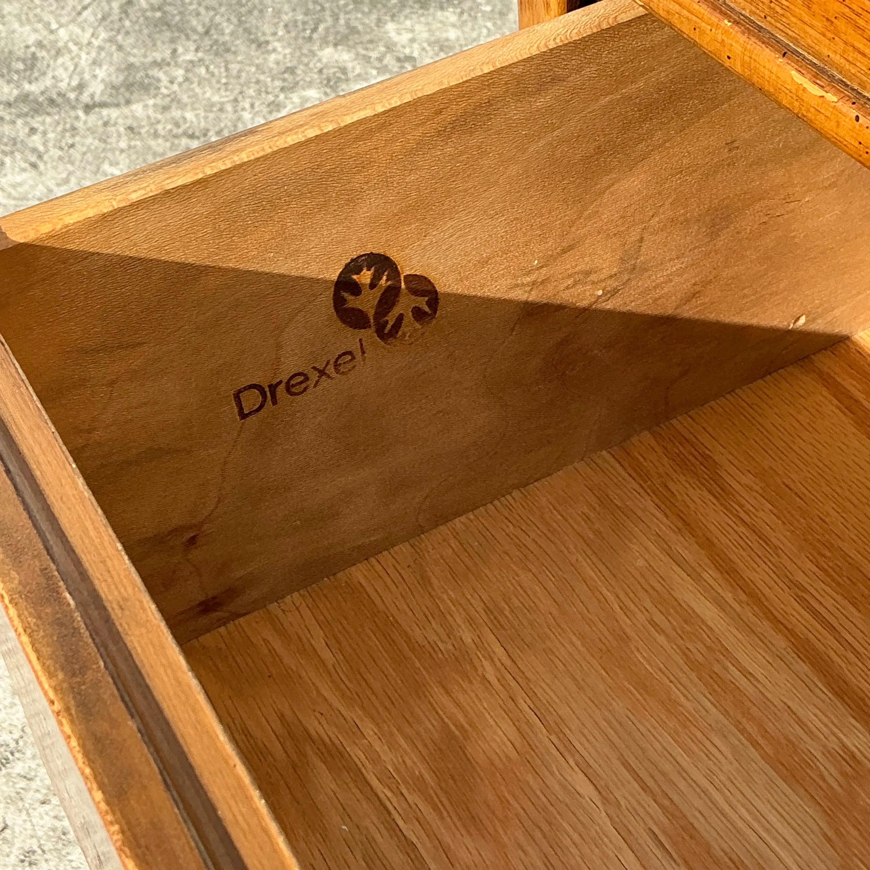 Splendida cassettiera alta vintage Drexel Campaigner con un tocco boho. Realizzato con un'eleganza senza tempo, presenta una ferramenta in ottone e un design elegante e funzionale. Perfetto per aggiungere spazio e stile a qualsiasi ambiente