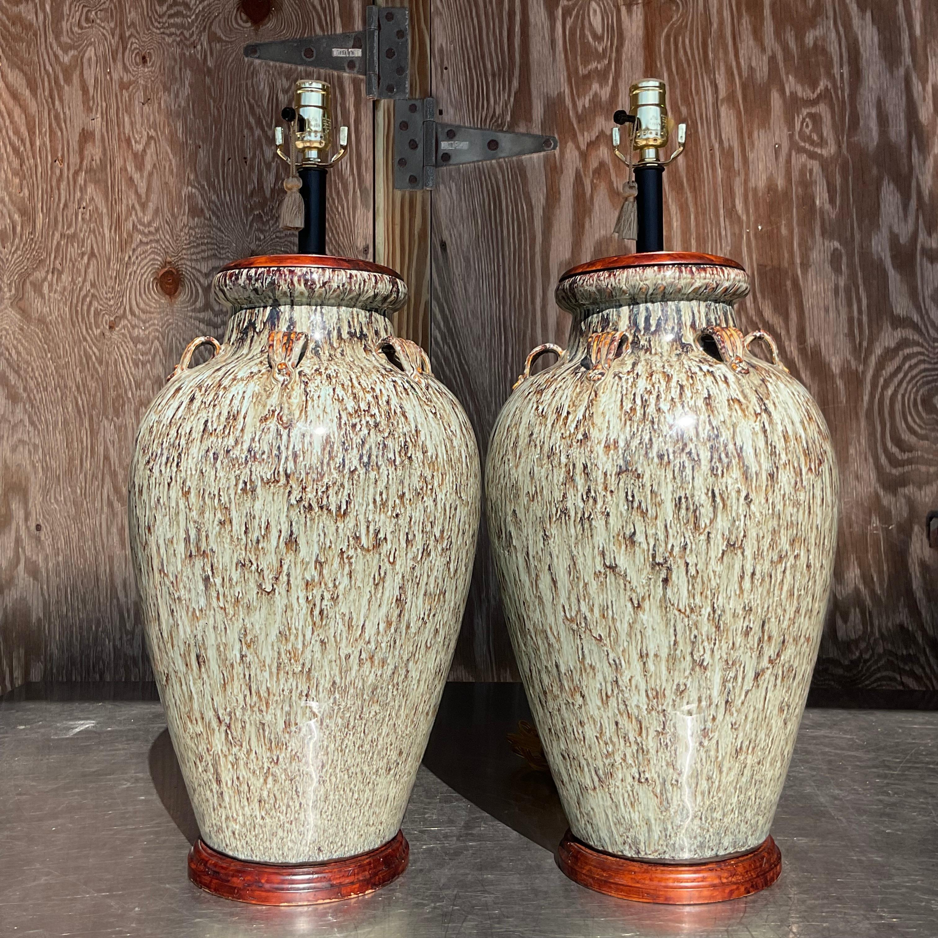 A fabulous pair of vintage Boho table lamps. A chic drip glass in shades of pale Celadon and brown. Rests on wooden plinths. Monumental in size and drama. Acquired from a Palm Beach estate.