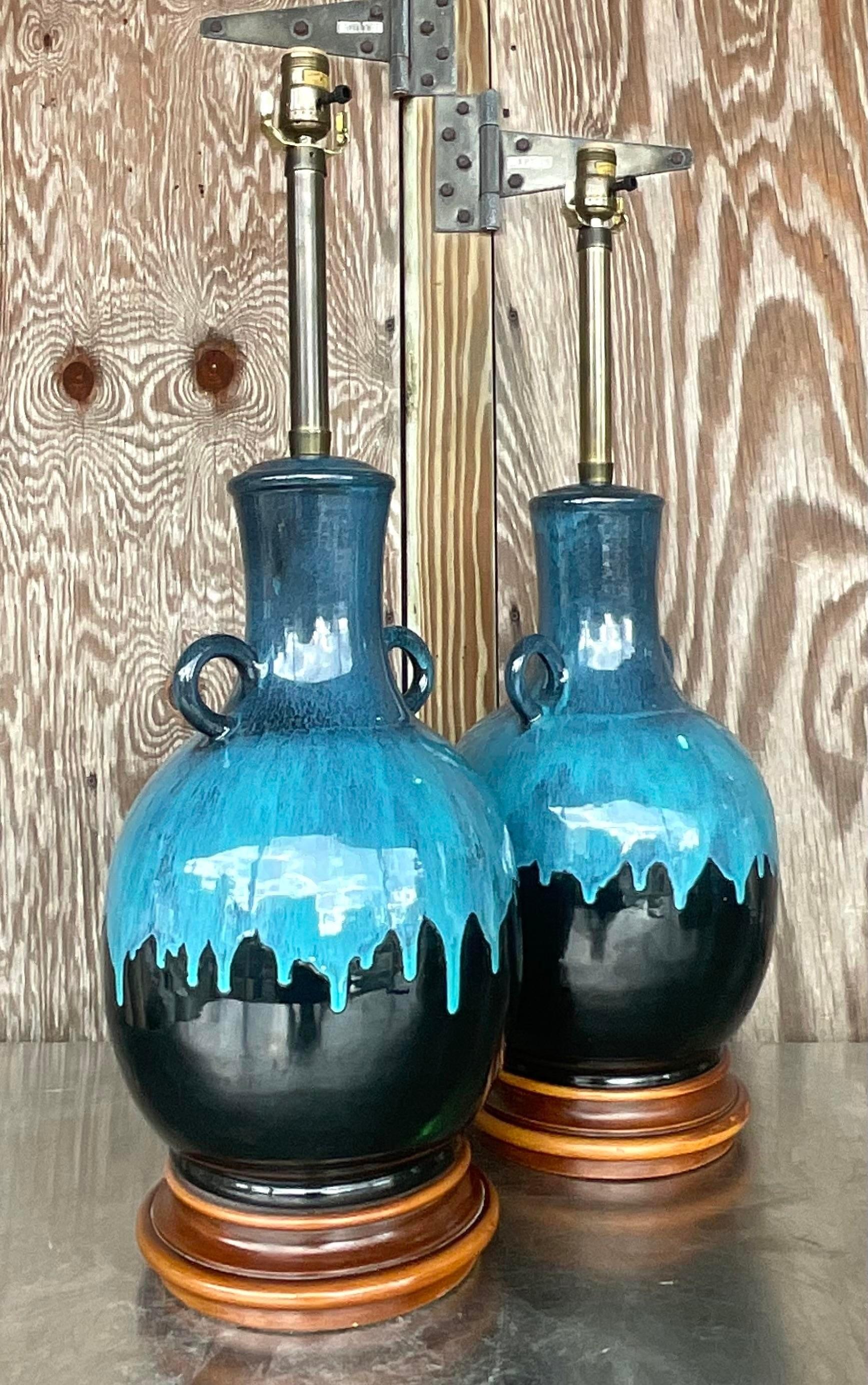 A fantastic pair of vintage Boho table lamps. A chic blue drip glaze on black ceramic. Rest of Burl wooden plinths. Fully restored with all new hardware and wiring. Acquired from a Miami estate.