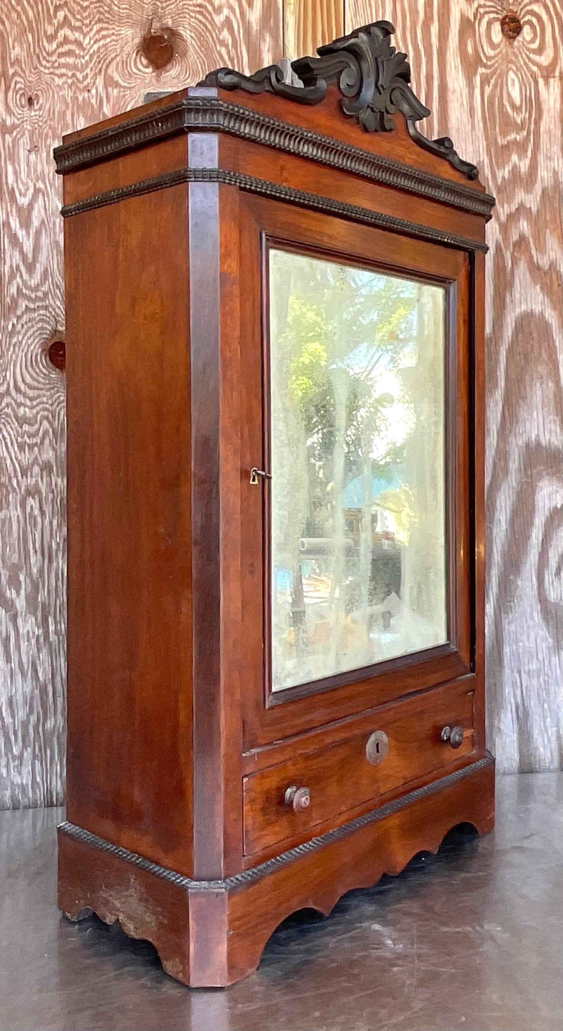 Add a dash of Bohemian charm to your space with our Vintage Eastlake Mirrored Tabletop Cabinet. Featuring intricate detailing and a mirrored tabletop, this piece seamlessly blends Victorian elegance with American Boho flair, offering a stylish