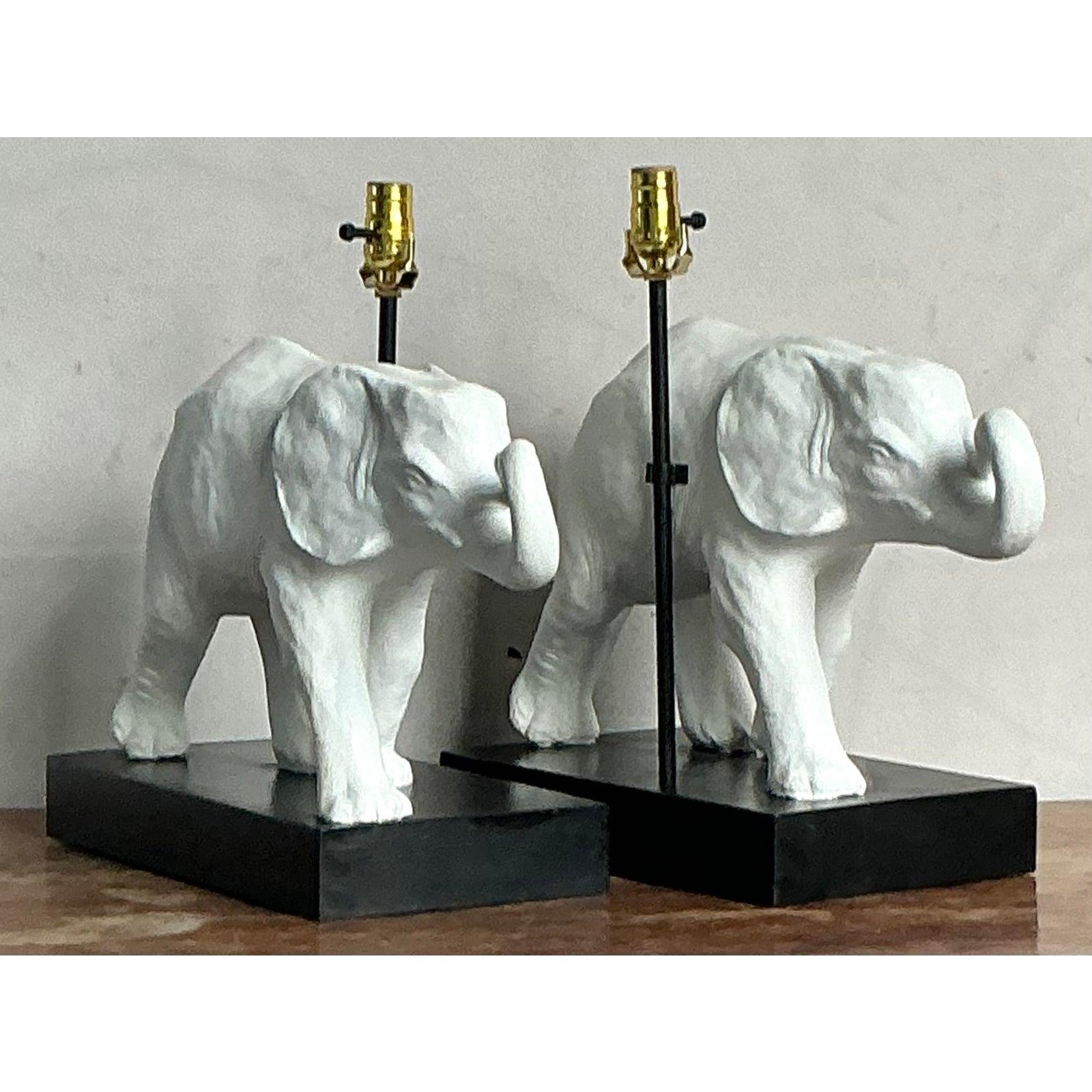 Élément d'éclairage à la fois fantaisiste et sophistiqué, cette lampe de table vintage présente un éléphant magnifiquement sculpté, d'un blanc mat éclatant, monté sur un socle noir ébonisé contrastant. L'éléphant est représenté dans un style