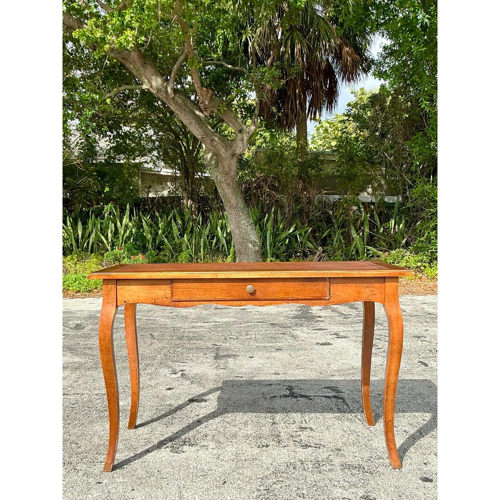 Eleganza senza tempo per il tuo spazio di lavoro grazie a questo squisito scrittoio in pelle goffrata vintage. Caratterizzata da una struttura in legno caldo con gambe cabriole graziosamente ricurve, questa scrivania mette in mostra un'artigianalità