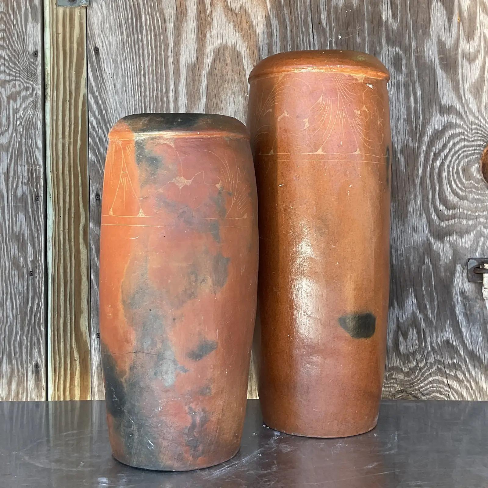 A n incredible set of two vintage Boho vases. Beautiful terracotta construction with rings of fine etched detail. Gorgeous display of fiery colors. Acquired from a Palm Beach estate.

Second vase 8 x 8 x 19.5.