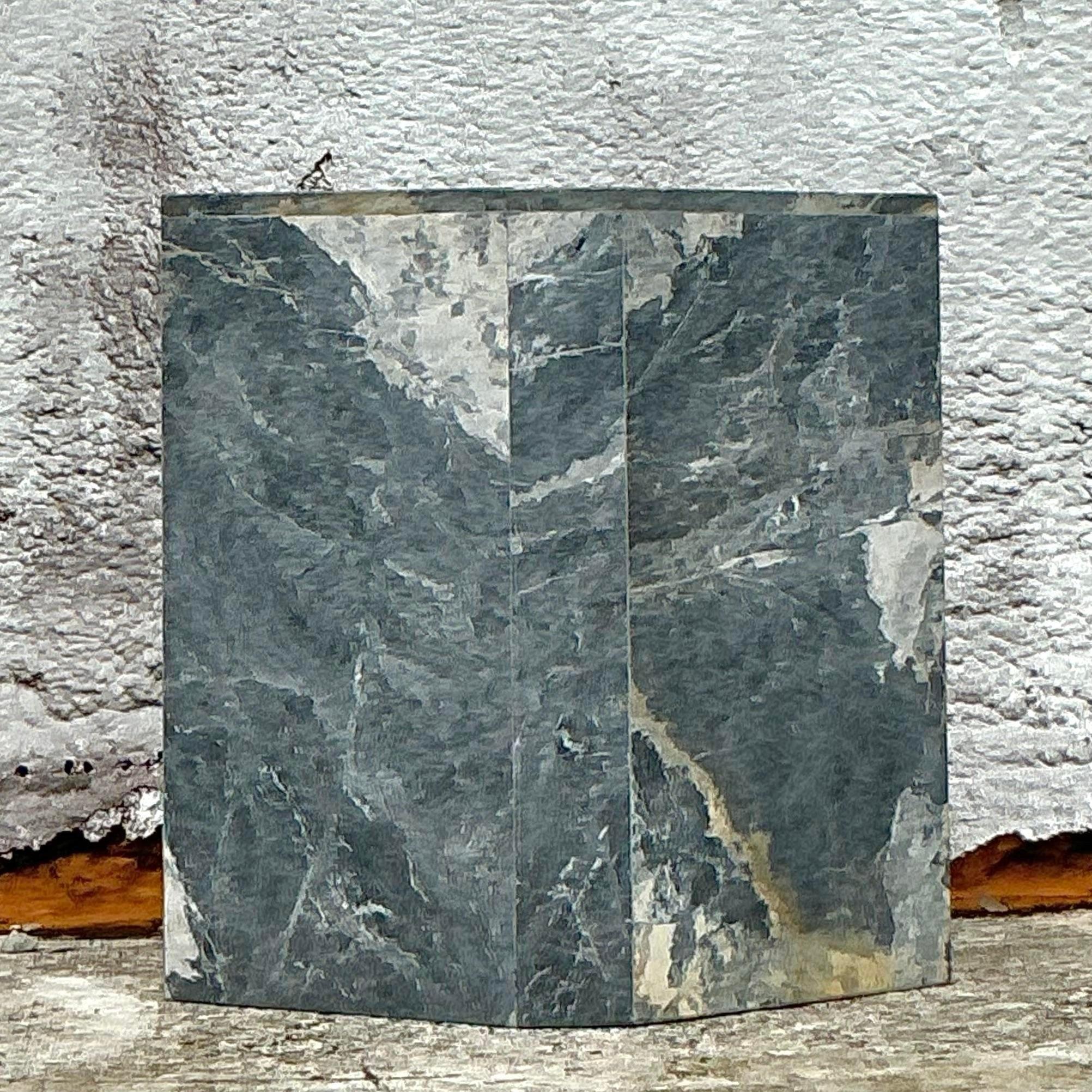 Faites une déclaration audacieuse avec ce piédestal en marbre gris à facettes Vintage By By. Son design sculptural et ses bords épurés et facettés apportent une touche de modernité à la beauté naturelle du marbre gris. Parfait pour exposer des