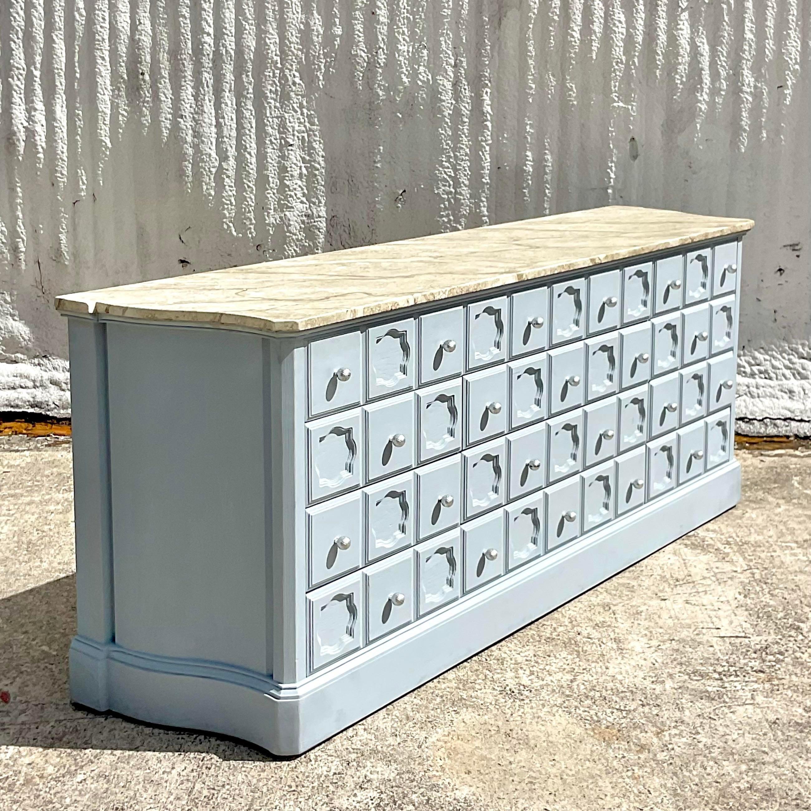 A spectacular Vintage Coastal credenza. A chic faux finish with a solid pale blue cabinet and a marbleized top. Lots of great storage below. Acquired from a Palm Beach estate.