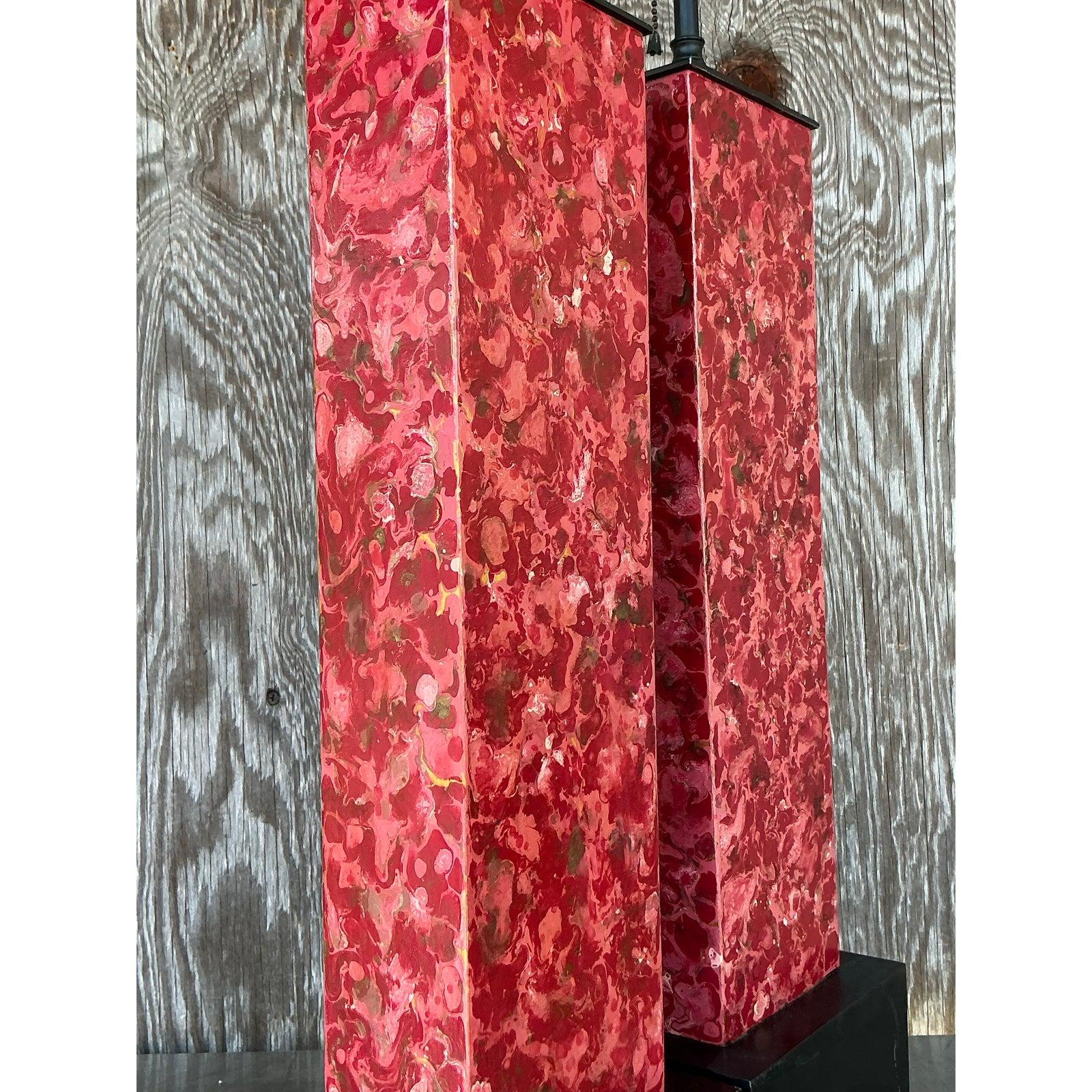Illuminez votre espace avec cette paire de lampes vintage en faux marbre, alliant l'élégance intemporelle à une touche artistique audacieuse. Ces lampes sculpturales présentent une finition marbrée rouge et or frappante sur une base rectangulaire