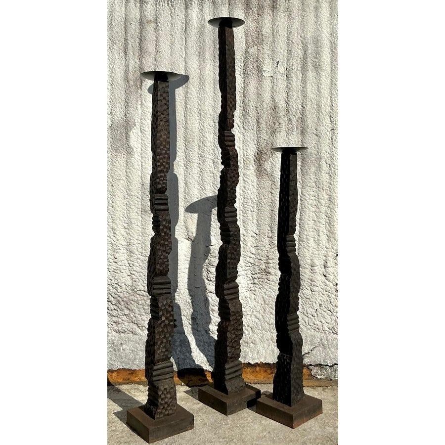 Peppen Sie Ihr Interieur mit diesem atemberaubenden Trio von Bodenkerzenständern im Vintage-Stil auf. Mit ihrem organischen, strukturierten Design und der robusten, patinierten Oberfläche verbinden diese Kerzenhalter rustikalen Charme mit böhmischer