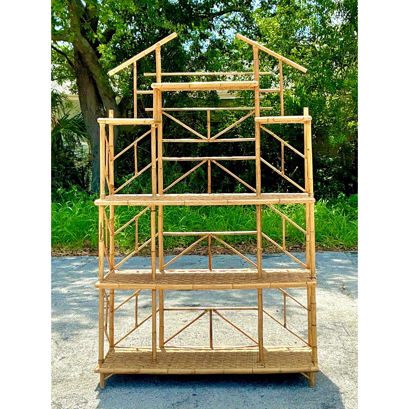 Elevate your interior with this magnificent Vintage French Riviera Bamboo & Wicker Etagere Bookshelf, a truly captivating piece that embodies the relaxed elegance and artistic spirit of Bohemian chic design. Crafted with exceptional skill and