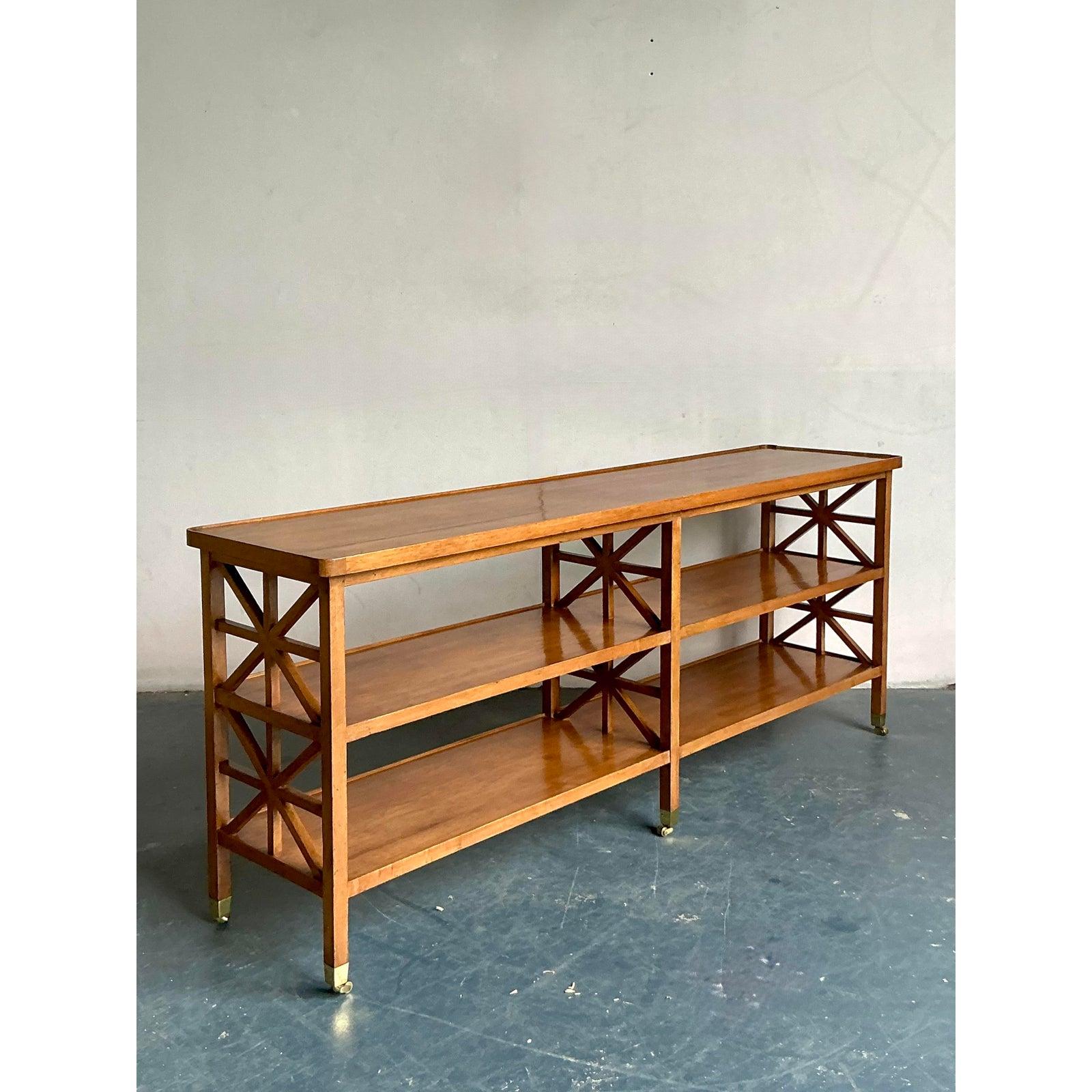 Infuse your home with global charm and sophisticated style with this vintage Boho Chic Fretwork Console Table. Crafted from rich wood, this striking piece features intricate fretwork detailing on its ends, adding a touch of exotic elegance and