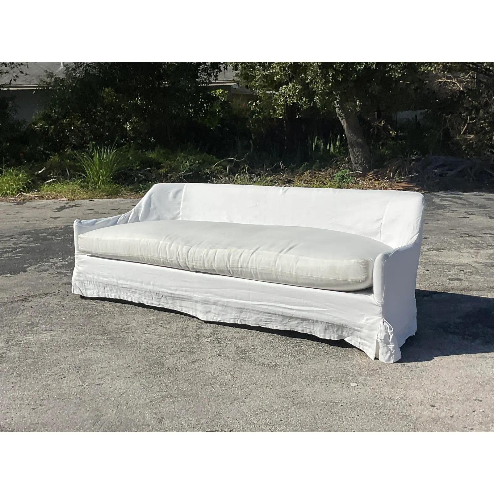 A fantastic vintage Boho sofa. Made by the legendary George Smith. A chic grey LeJuene upholstery with subtle shade variations with the cushion and sofa. The sofa also includes a full white linen slipcover. Acquired from a Palm Beach estate.