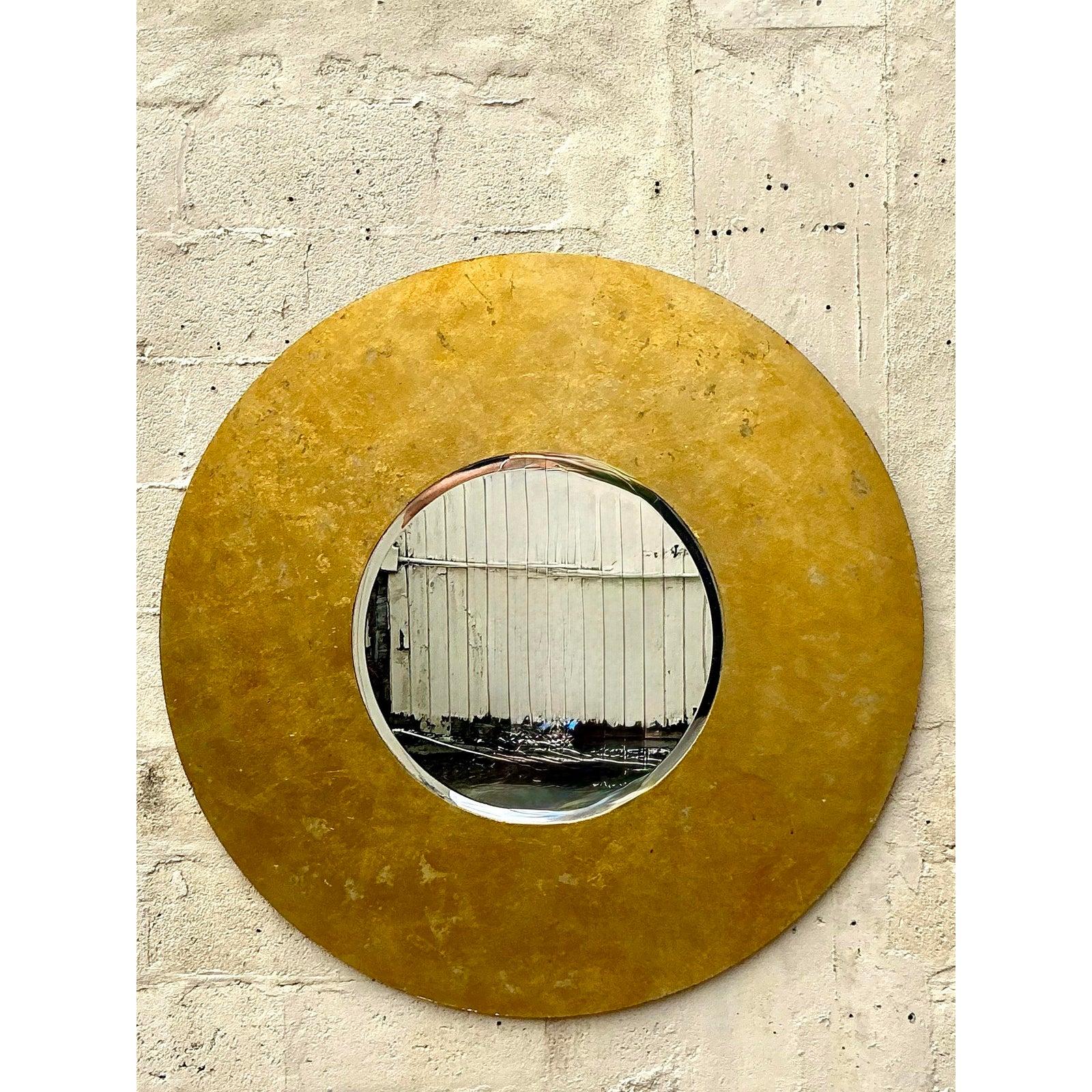 Faites une déclaration spectaculaire avec ce miroir monumental doré de style Vintage By By. Ce miroir rond impressionnant présente un cadre large et substantiel avec une finition dorée richement texturée qui respire l'opulence vintage et la grandeur