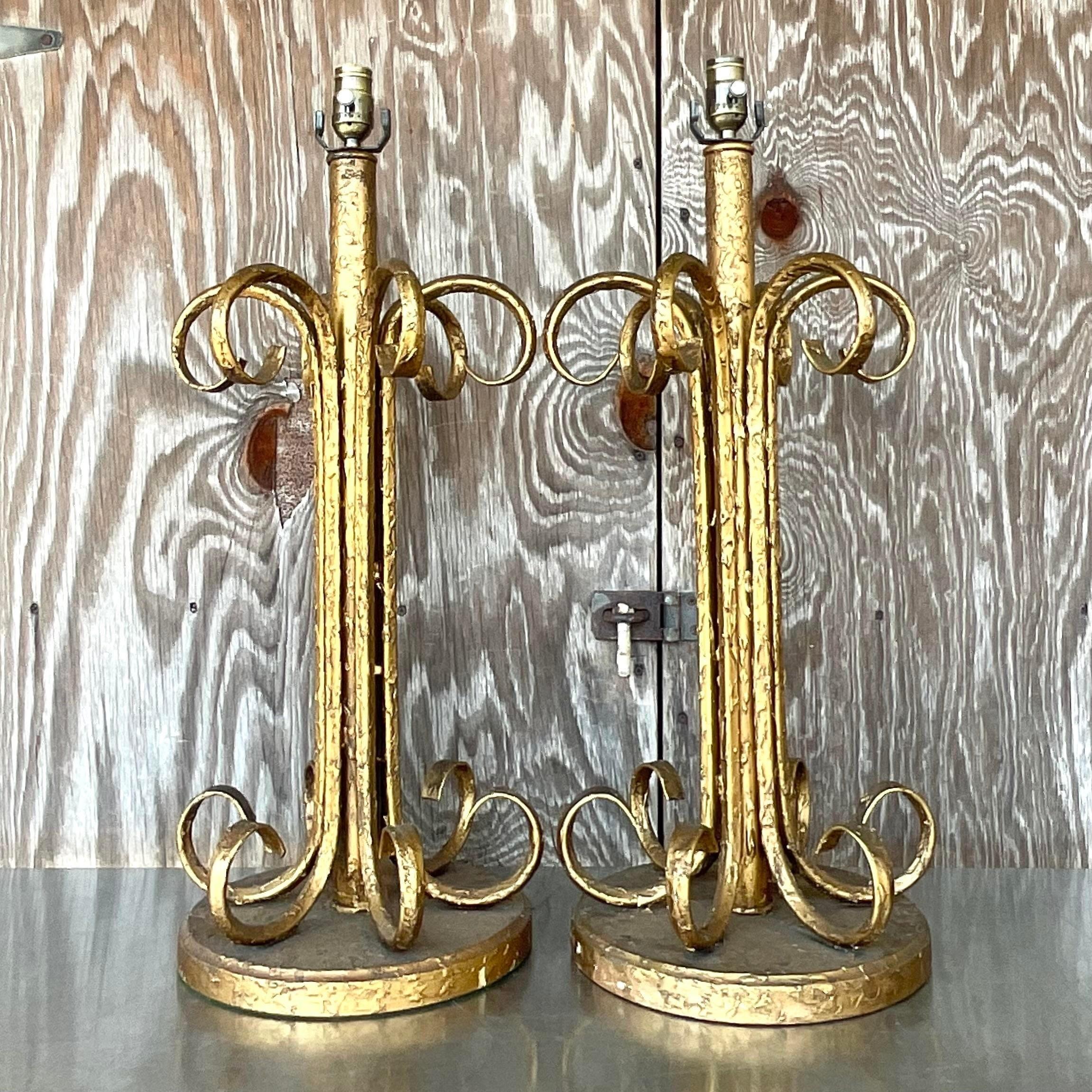 Una favolosa coppia di lampade da tavolo monumentali. Finitura dorata chic con un affascinante design a volute. Acquistato da una proprietà di Palm Beach.