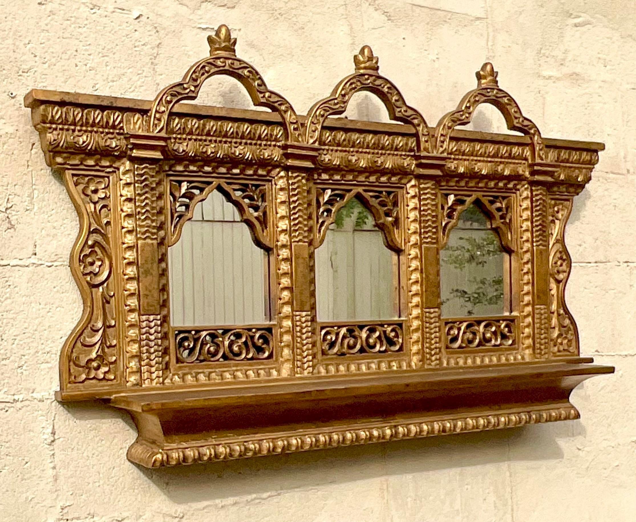 Un superbe miroir mural Boho vintage. Un design chic en forme d'arc de temple dans une finition dorée chaleureuse. Un excellent moyen d'ajouter une touche de drame à n'importe quel espace. Acquis d'une propriété de Palm Beach. 