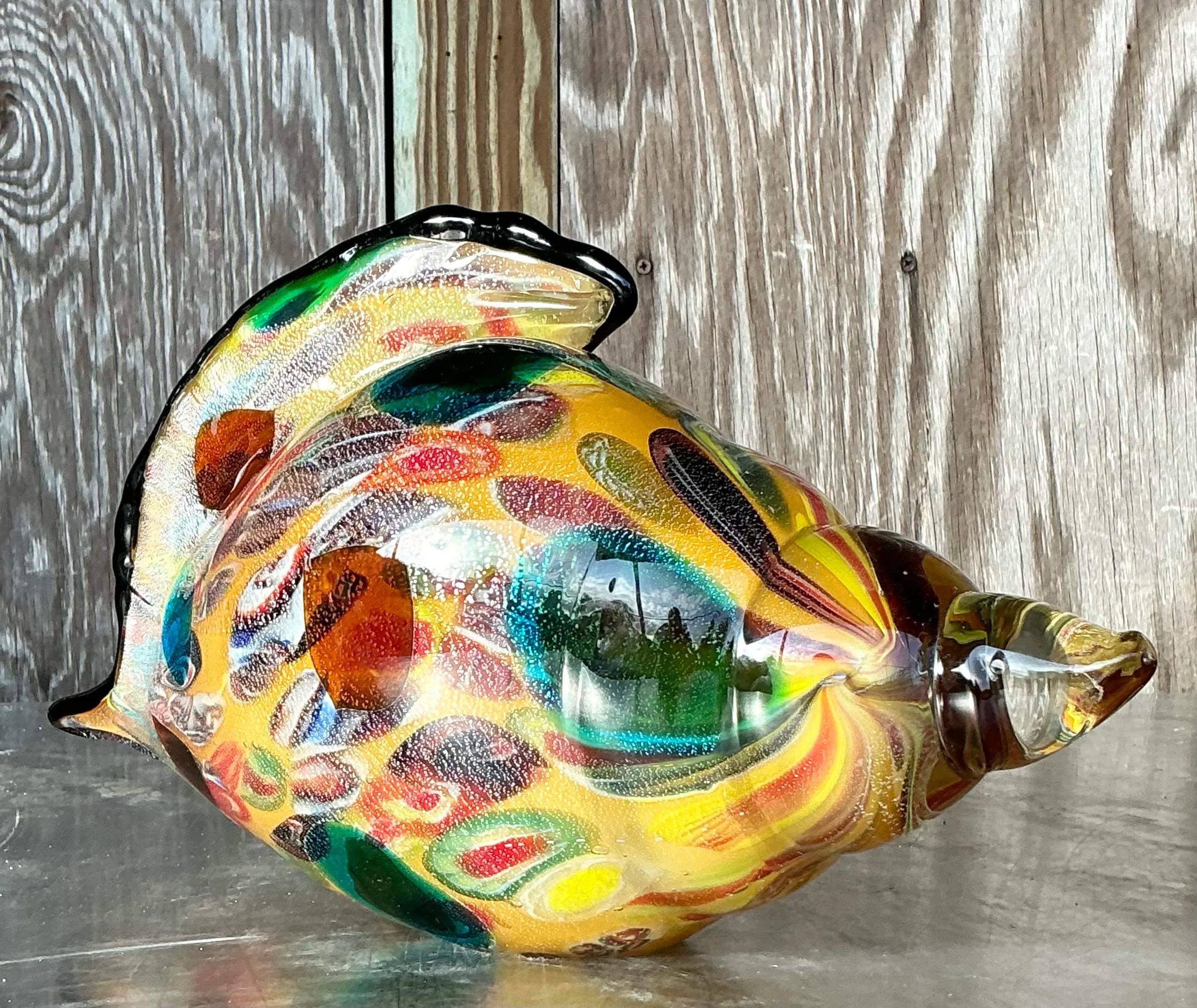 Questa conchiglia bohémienne in vetro di Murano è un pezzo decorativo accattivante che emana fascino artigianale ed eleganza costiera. Realizzata nello stile dei vetrai di Murano, questa scultura presenta una forma di vetro soffiato che ricorda una