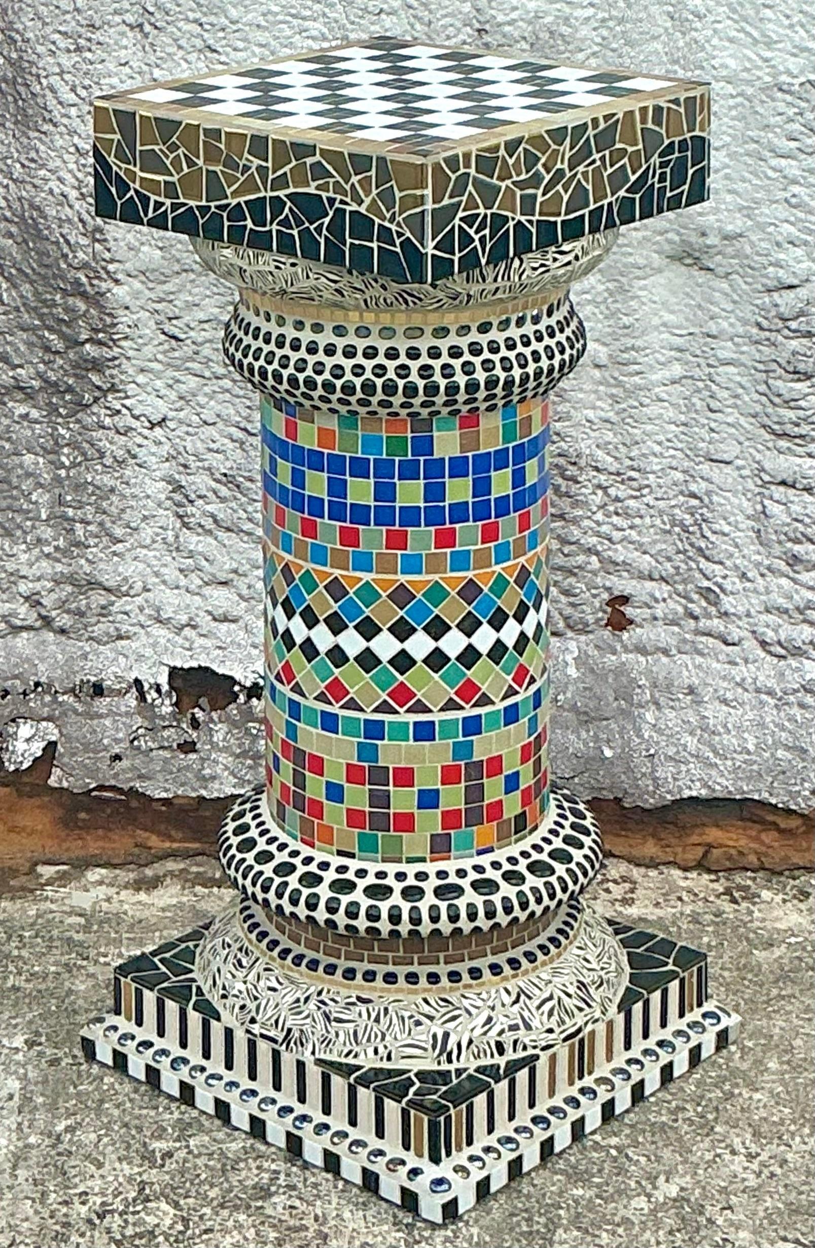 Elevate your decor with this stunning Vintage Boho Glass Mosaic Pedestal. Covered in intricate, colorful glass tiles, this pedestal is a work of art that brings texture, vibrancy, and a touch of whimsy to any space. The mosaic pattern catches the