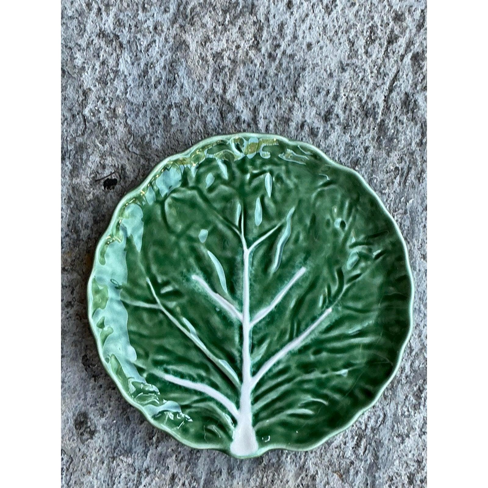 Améliorez votre collection de plats avec ce magnifique ensemble de quatre assiettes en céramique émaillée vintage, magnifiquement travaillées pour ressembler à des feuilles de chou détaillées. Chaque assiette présente une finition verte brillante et