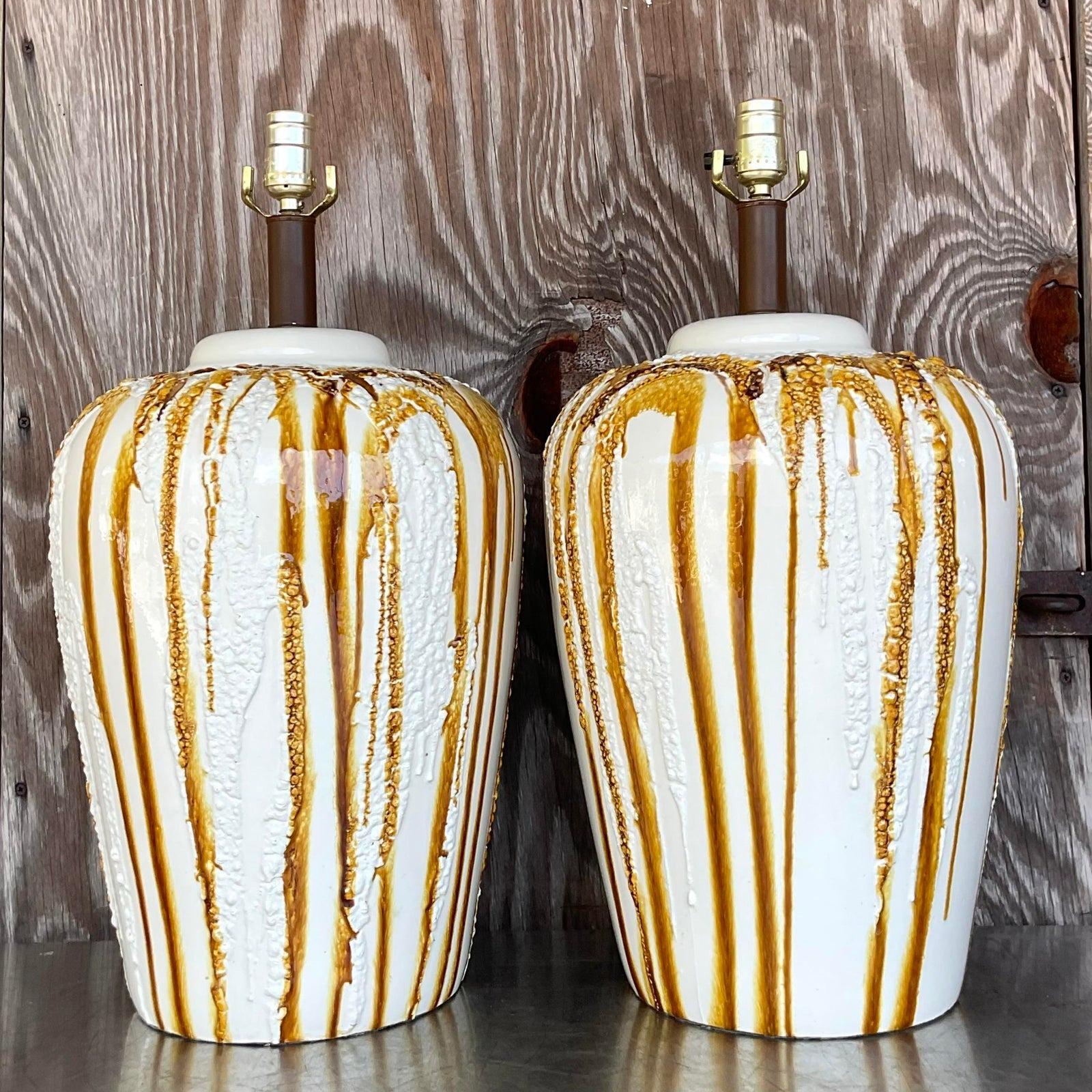 A stunning pair of vintage Boho table lamps. A heavy pottery with a drip glaze in brown over white. Monumental in size and drama. Acquired from a Palm Beach estate.