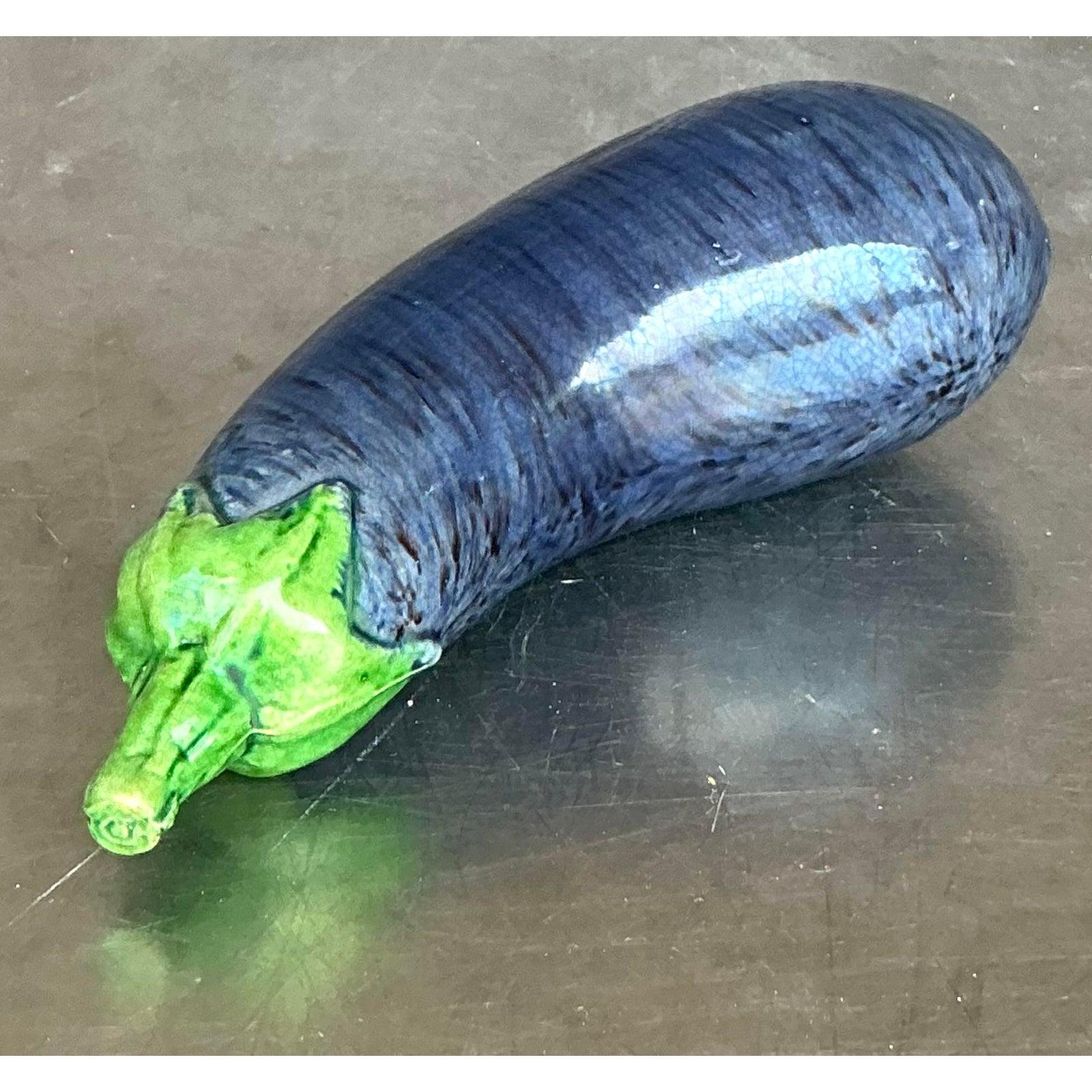 Ajoutez une touche fantaisiste de décoration inspirée de la nature à votre intérieur avec cette charmante aubergine vintage en céramique émaillée. Cette pièce est un bel exemple de céramique décorative, sculptée de façon réaliste et recouverte d'une