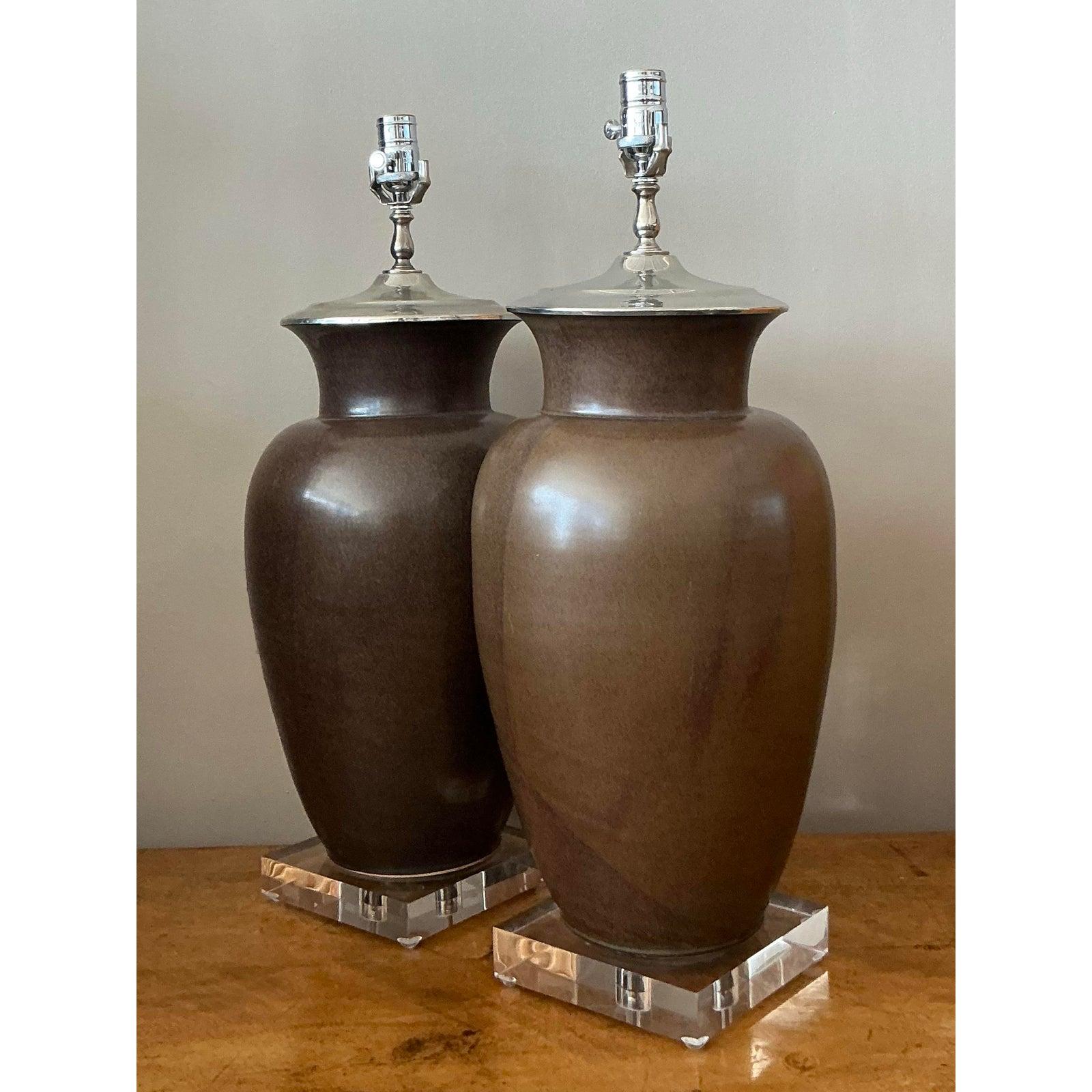 Eleva tu decoración con este exquisito par de lámparas de mesa de cerámica vintage, una fusión magistral de forma clásica y glamour moderno. Cada lámpara tiene un cuerpo sólido con forma de urna, acabado en un rico esmalte marrón texturizado que le