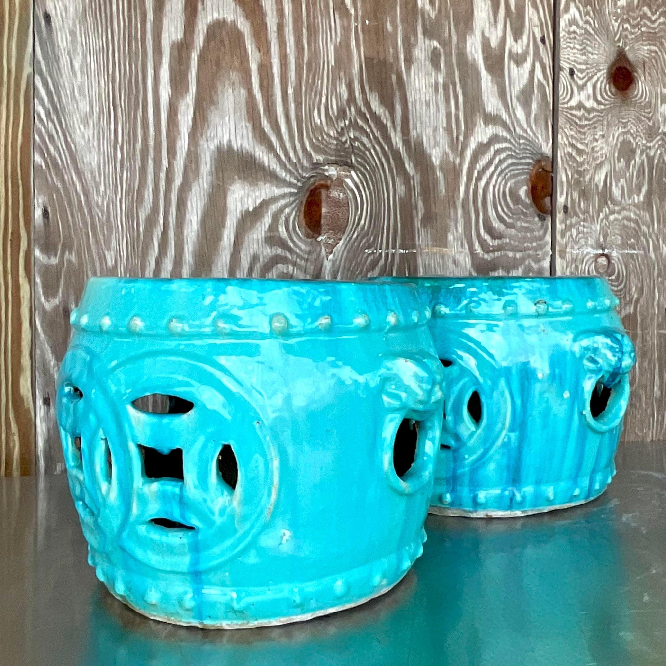 A fabulous pair of vintage low stools. A chic glazed ceramic finish in a brilliant blue/green color. A beautiful open medallion design. Acquired from a Palm Beach estate.