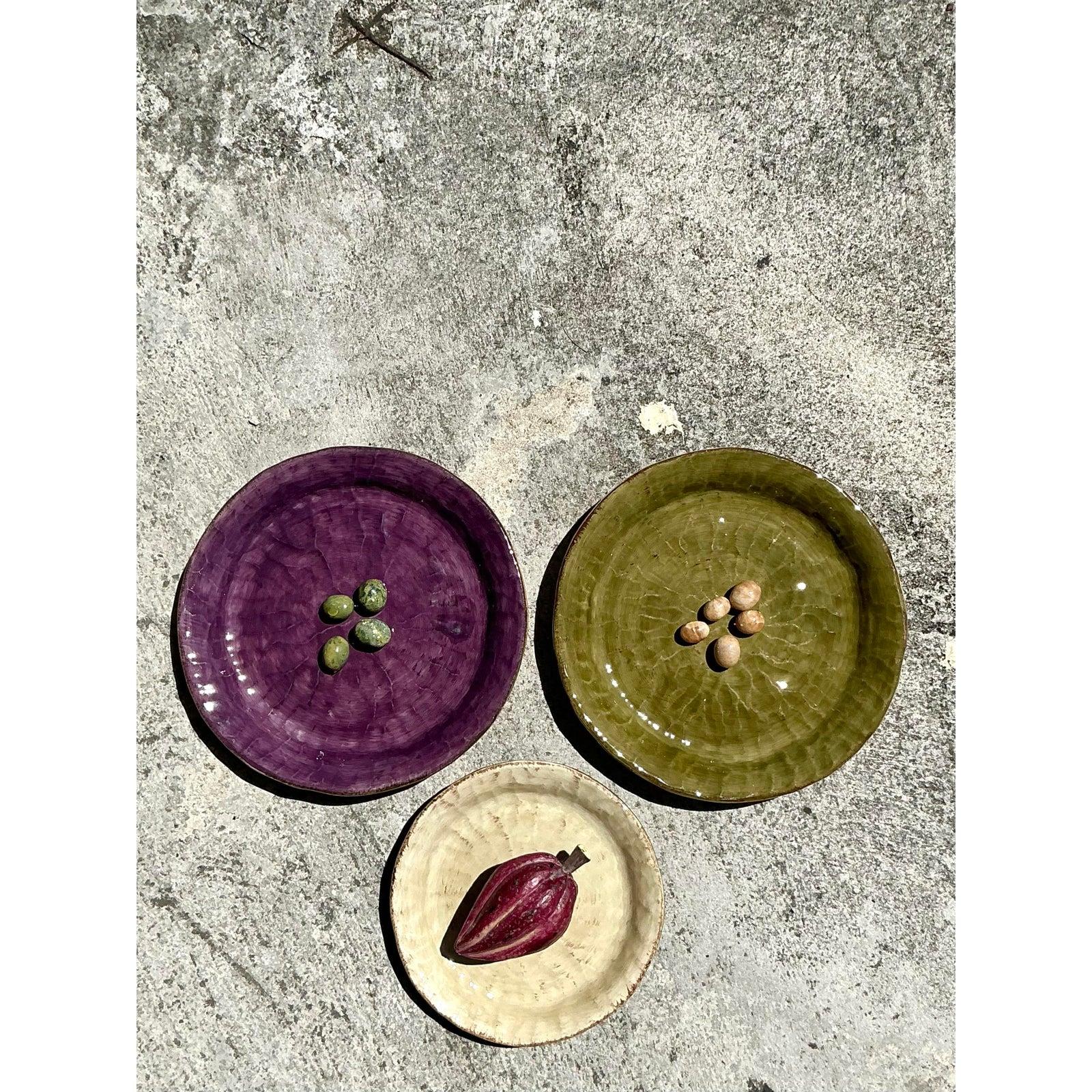 Ce superbe set de trois assiettes en céramique vintage présente une finition exquise émaillée à la main dans des tons riches et terreux de violet profond, de vert olive et de crème neutre. La glaçure joliment craquelée rehausse la texture naturelle,