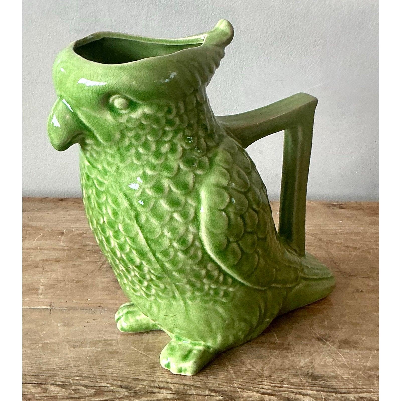 Inject a dose of whimsical charm into your home with this delightful vintage Boho Chic glazed ceramic parrot pitcher. This unique piece captures the vibrant spirit of nature with its figural parrot design, exquisitely rendered with textured