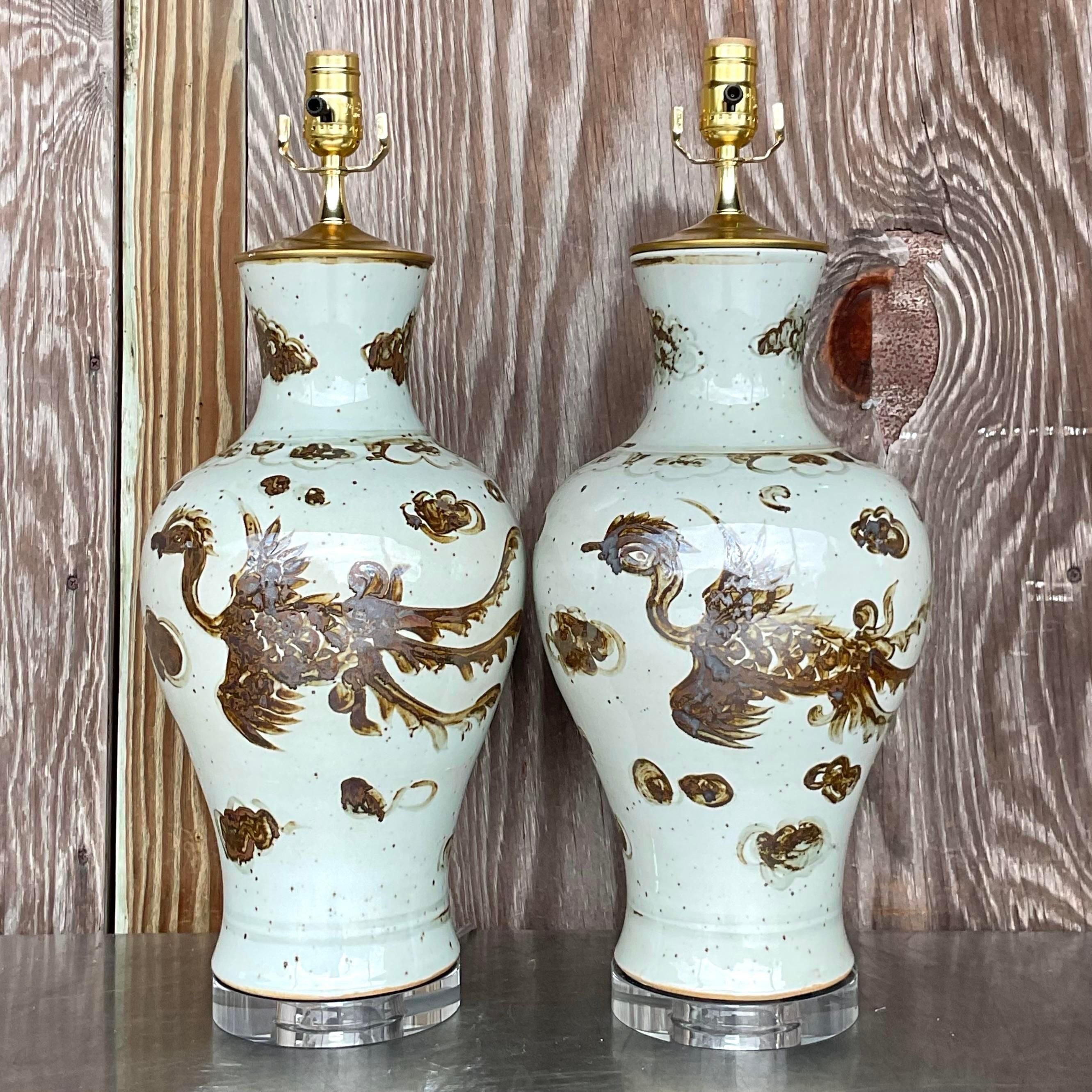 A stunning pair of vintage Boho table lamps. A chic Phoenix design on a glazed heavy ceramic vase. Monumental in size and drama. Acquired from a Palm Beach estate.