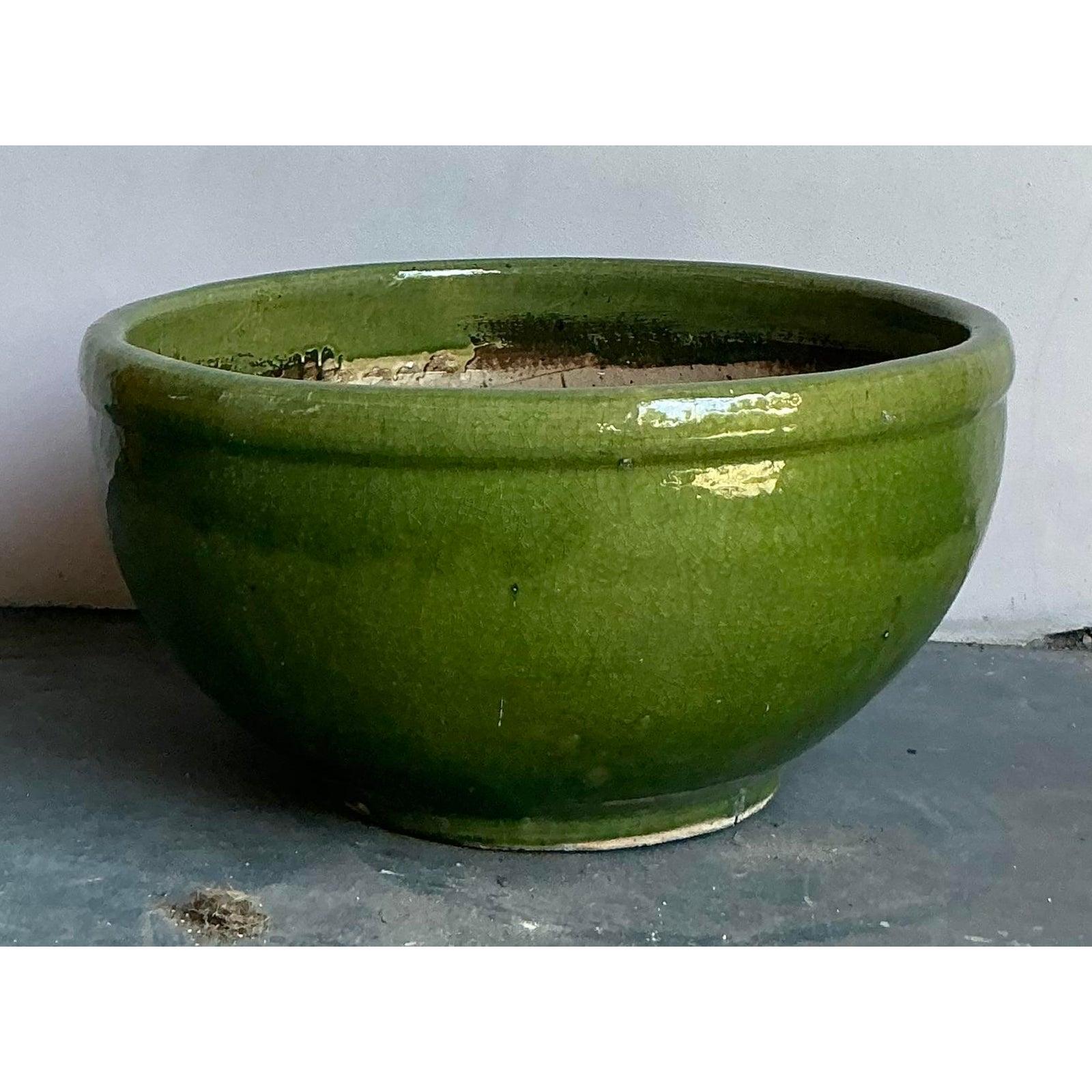 Infuse your space with a vibrant touch of artistry with this stunning vintage ceramic planter. Featuring a classic, low-bowl silhouette, this substantial piece is distinguished by its brilliant green glaze and beautiful crackle finish, which lends