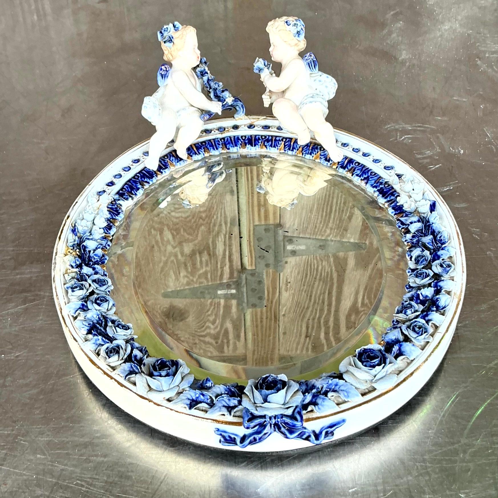 Un extraordinaire miroir Regency vintage. Belle composition en céramique émaillée bleue et blanche avec de charmants petits chérubins Putti. Acquis d'une propriété de Palm Beach.