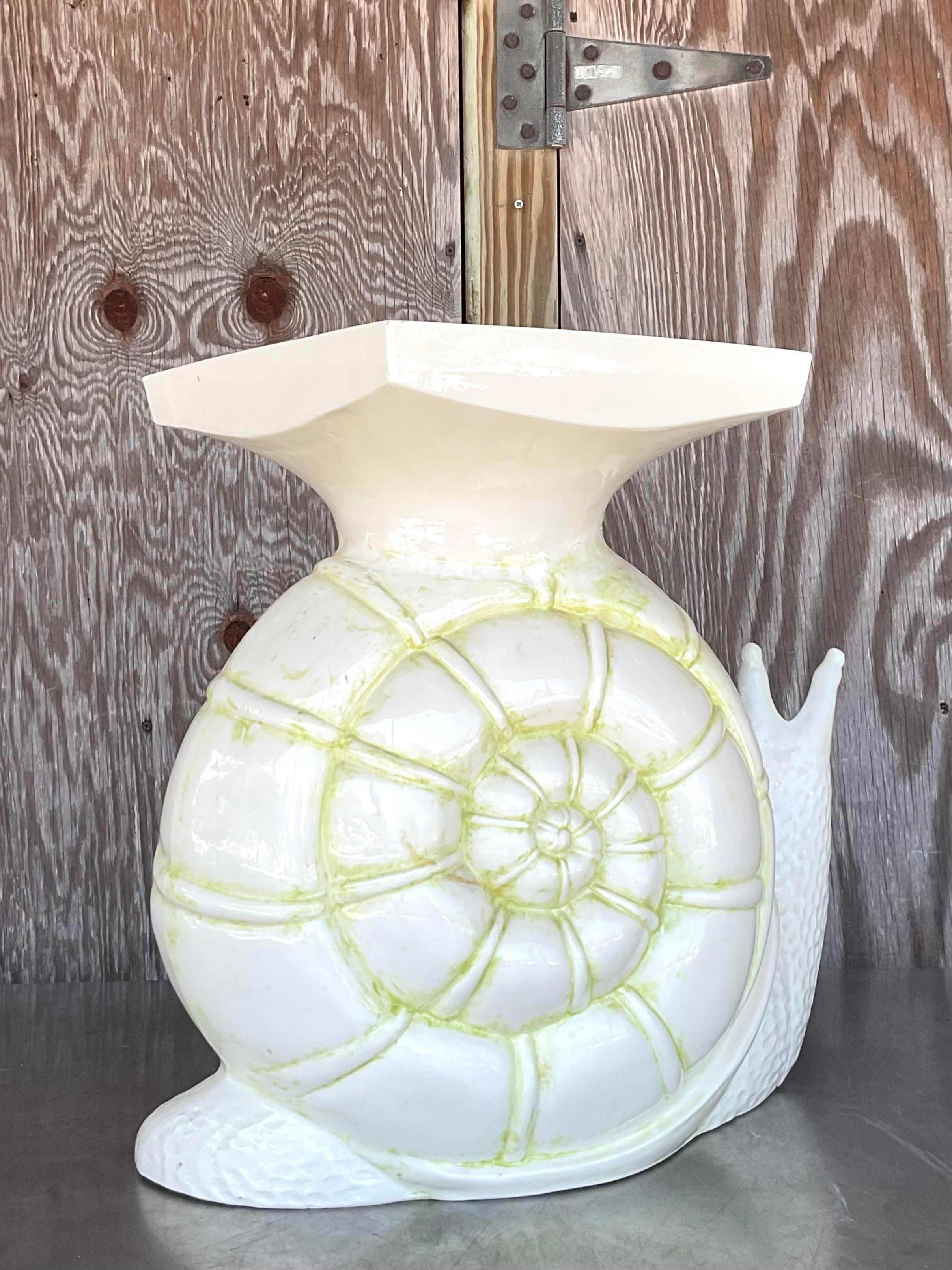 The Vintage Boho Glazed Ceramic Snail Low Stool adds a touch of whimsical charm to American style with its unique design and glazed ceramic craftsmanship. This playful stool blends vintage boho vibes with artisanal flair, making it a delightful