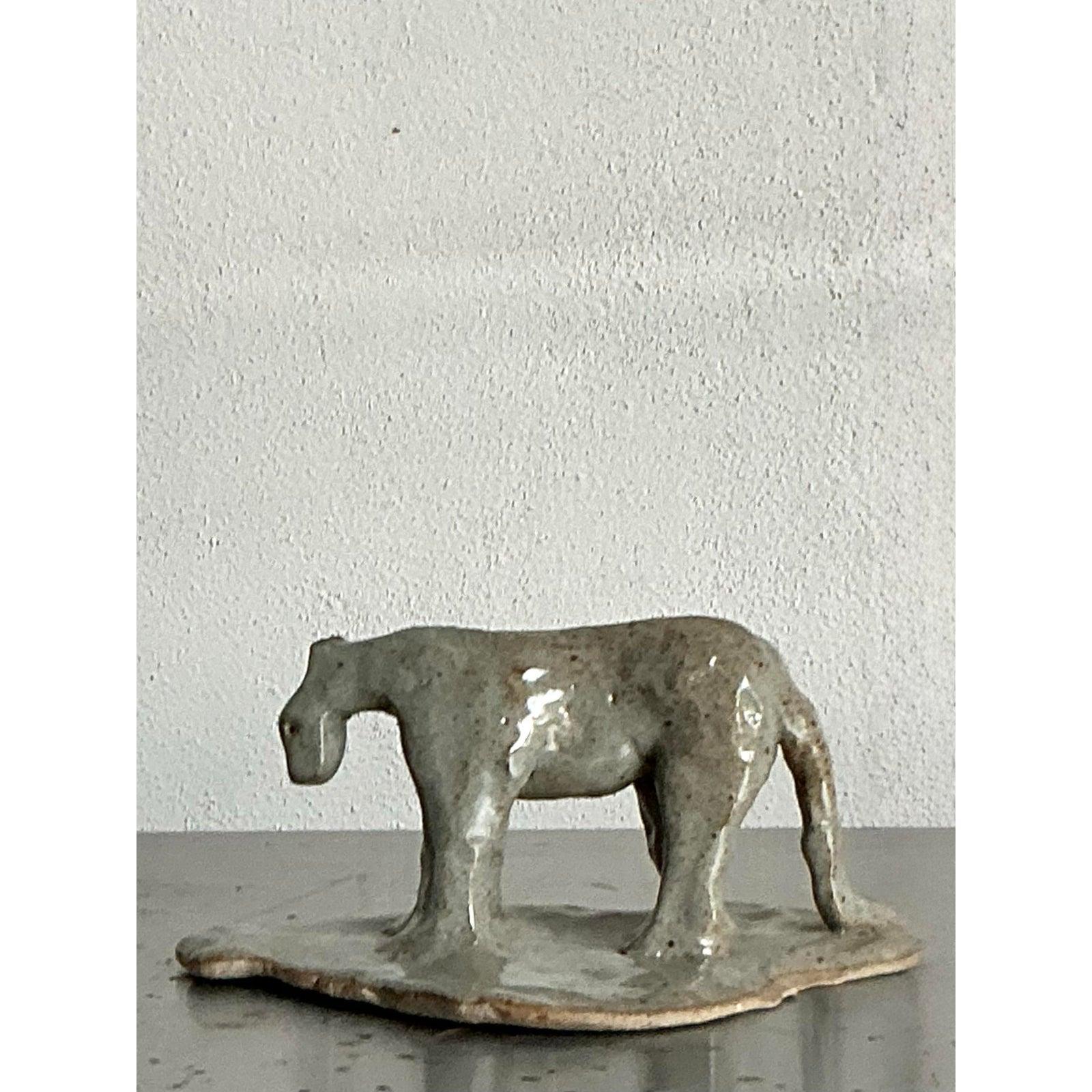 Ti presentiamo un'affascinante statuetta di tigre in ceramica smaltata vintage, un pezzo unico di artigianato che incarna un'estetica Boho distintiva. Questa intrigante scultura cattura la forma maestosa di una tigre con una qualità astratta, quasi