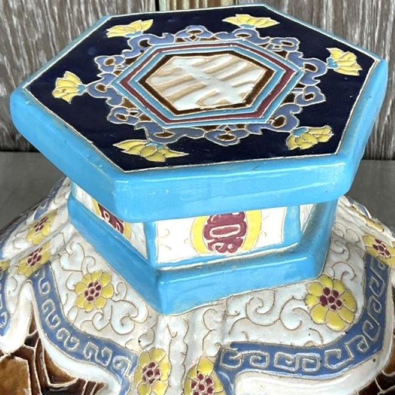 This unique vintage boho stool is crafted in the shape of an intricately detailed turtle. Hand-glazed with beautiful multicolor patterns, it exudes a blend of playful charm and artistic craftsmanship. The stool showcases an earthy and vibrant color