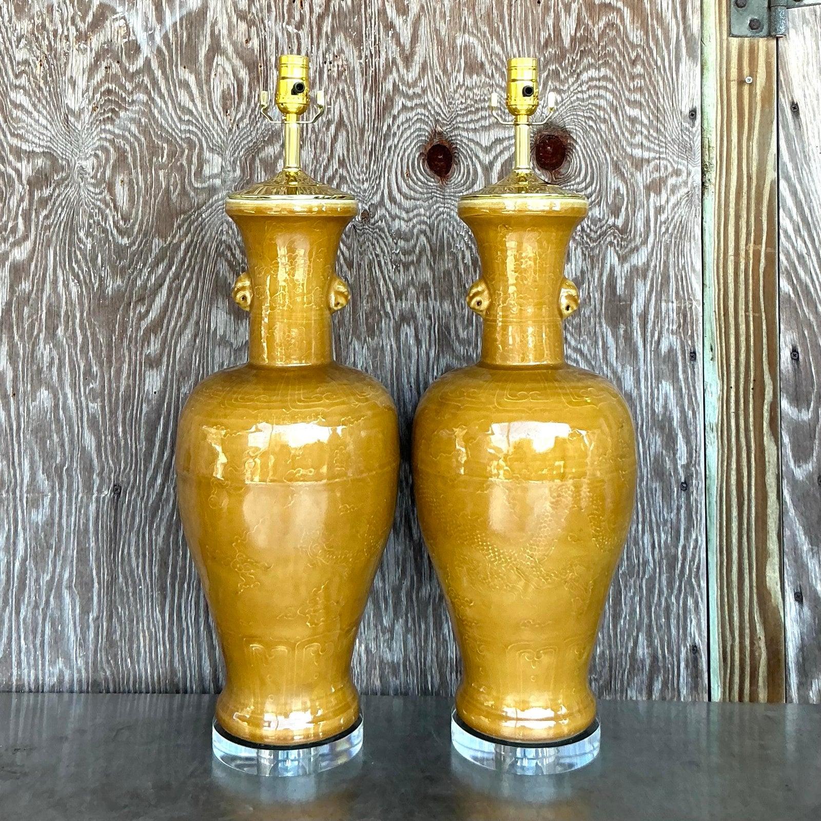 Infunde encanto ecléctico a tu espacio con este llamativo par de lámparas de porcelana vintage. Con un rico y vibrante esmalte amarillo mostaza, estas lámparas presentan una silueta de jarrón clásico elevada por sutiles e intrigantes detalles en