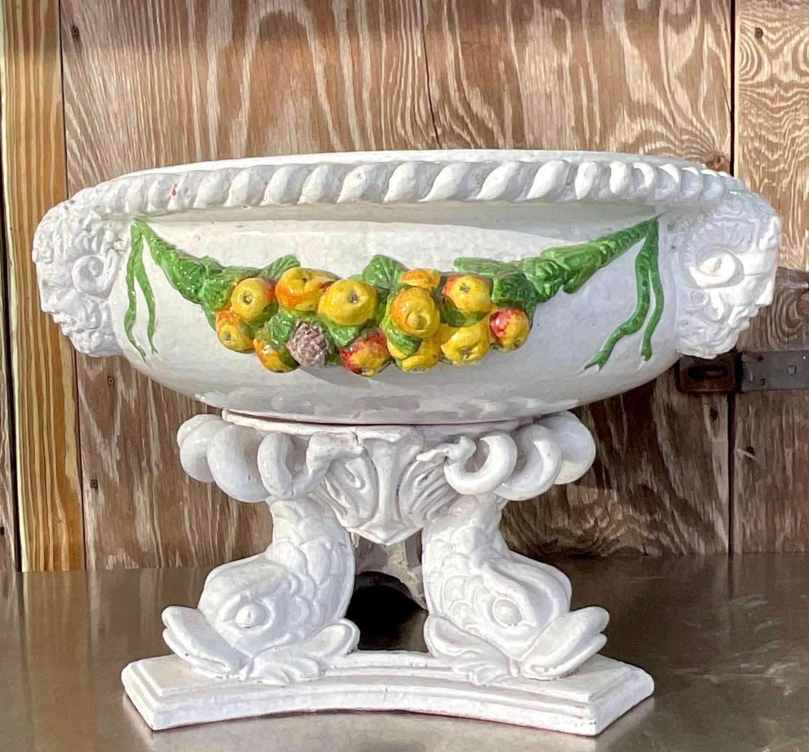 A fabulous vintage Coastal wide urn. A chic terracotta body in a glazed ceramic finish. Hand painted garland detail along with koi fish and warrior heads. Perfect indoors or outside. Acquired from a Palm Beach estate.