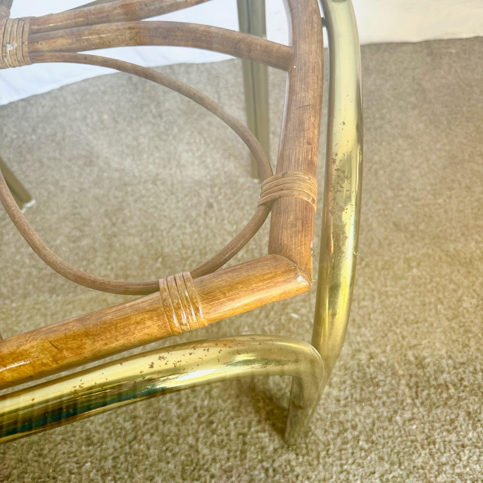 Table de salle à manger vintage Boho en or et rotin avec une base sculpturale en rotin, des pieds en laiton et une surface arrondie en verre, parfaite pour les intérieurs éclectiques.
 
 Piqûres sur le métal et une fissure esthétique dans le rotin