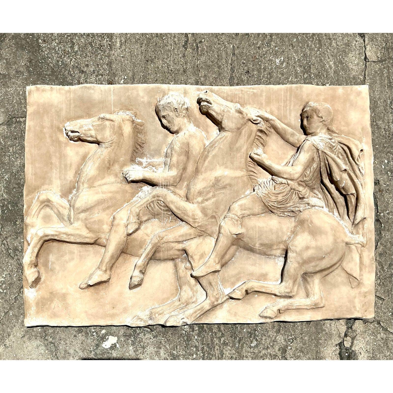 Eleganza classica dell'antichità con questo affascinante fregio vintage in stile Boho Grand Tour. Ispirata alla maestosa arte dell'antica Grecia e di Roma, questa targa decorativa da parete raffigura una dinamica scena equestre che ricorda le