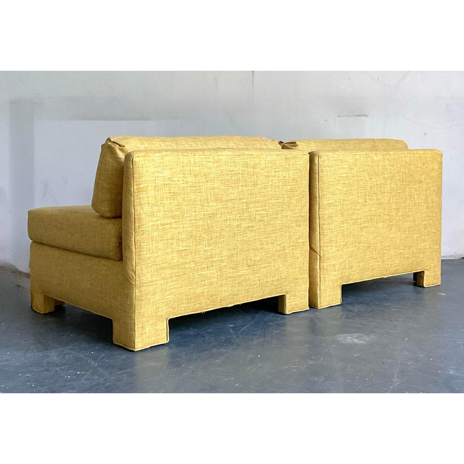 Embrace the bold, architectural spirit of 1970s design with this stunning pair of vintage slipper chairs. Upholstered in a highly textural marigold yellow grasscloth, these chairs are a feast for the senses, offering both visual depth and a unique