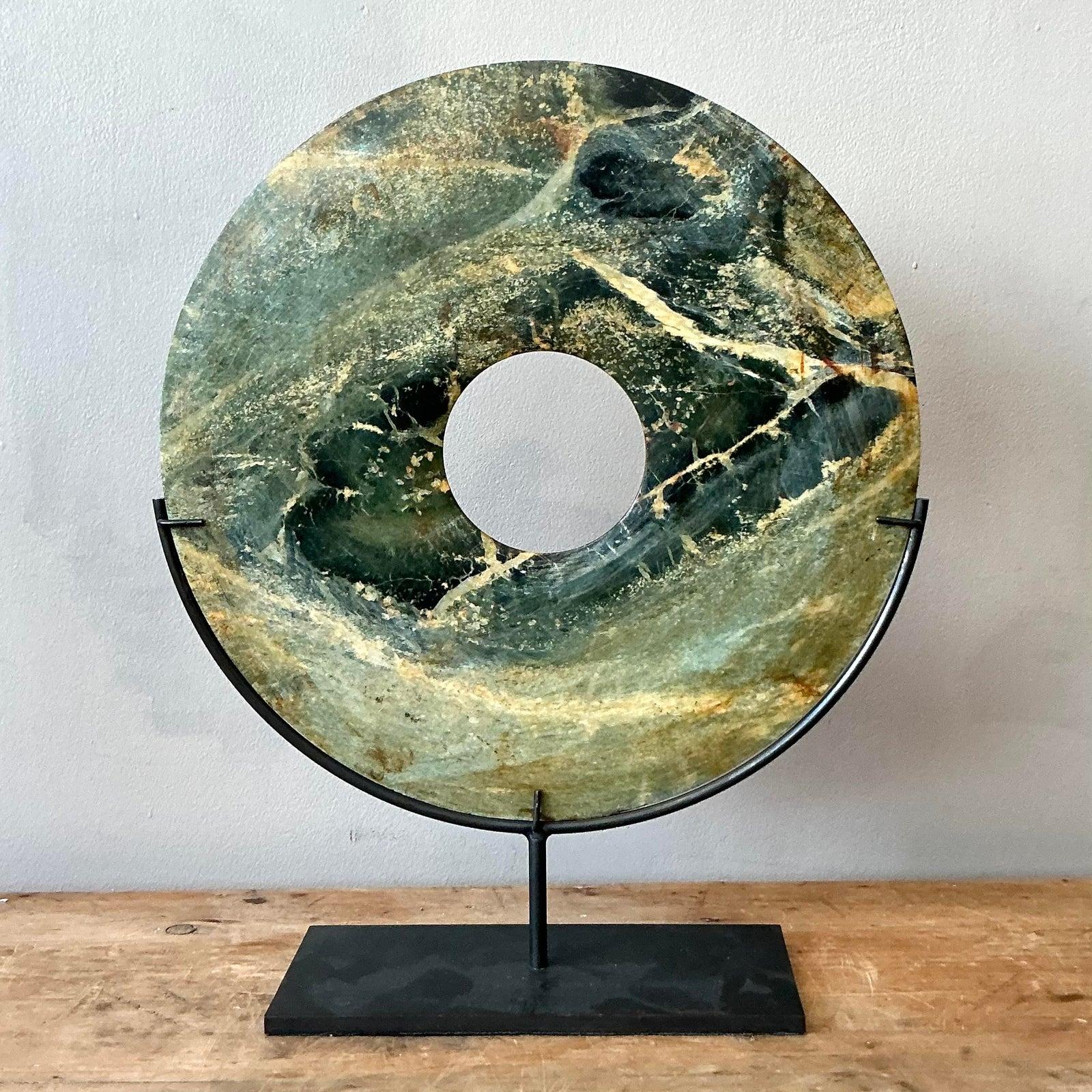 Questa splendida scultura bi-disco in marmo verde vintage incarna l'equilibrio tra bellezza organica e design minimalista. Ispirato all'antico simbolismo cinese, il disco di pietra liscia presenta accattivanti tonalità di verde, oro e nero, con