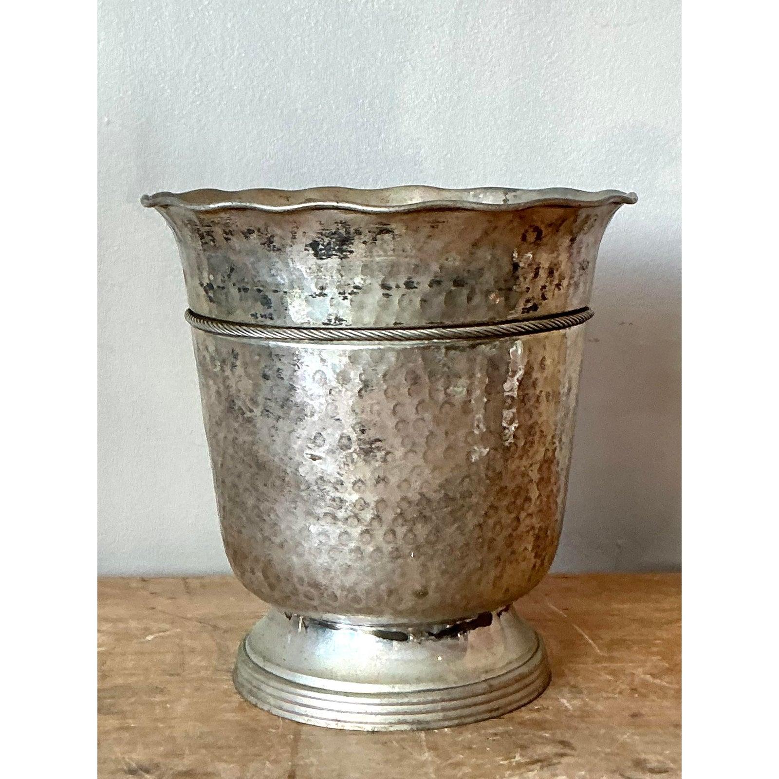 This exceptional vintage vessel showcases rustic craftsmanship paired with utilitarian elegance, functioning perfectly as an ice bucket, wine cooler, or decorative tureen. The body is crafted from hammered aluminum or possibly pewter, giving it a