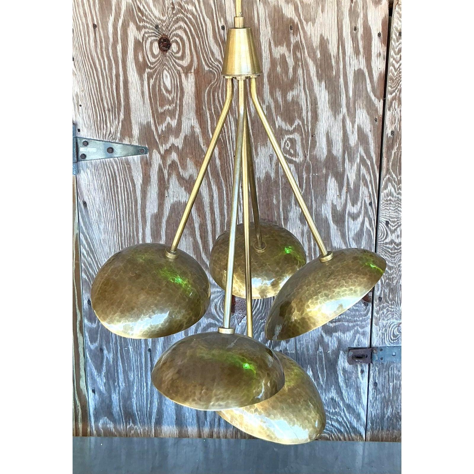 Illuminez votre espace avec l'éclat chaleureux et la texture unique de ce lustre vintage en laiton martelé, qui rappelle les étonnants designs modernistes souvent associés à des fabricants tels qu'Arteriors. Ce luminaire captivant présente une tige