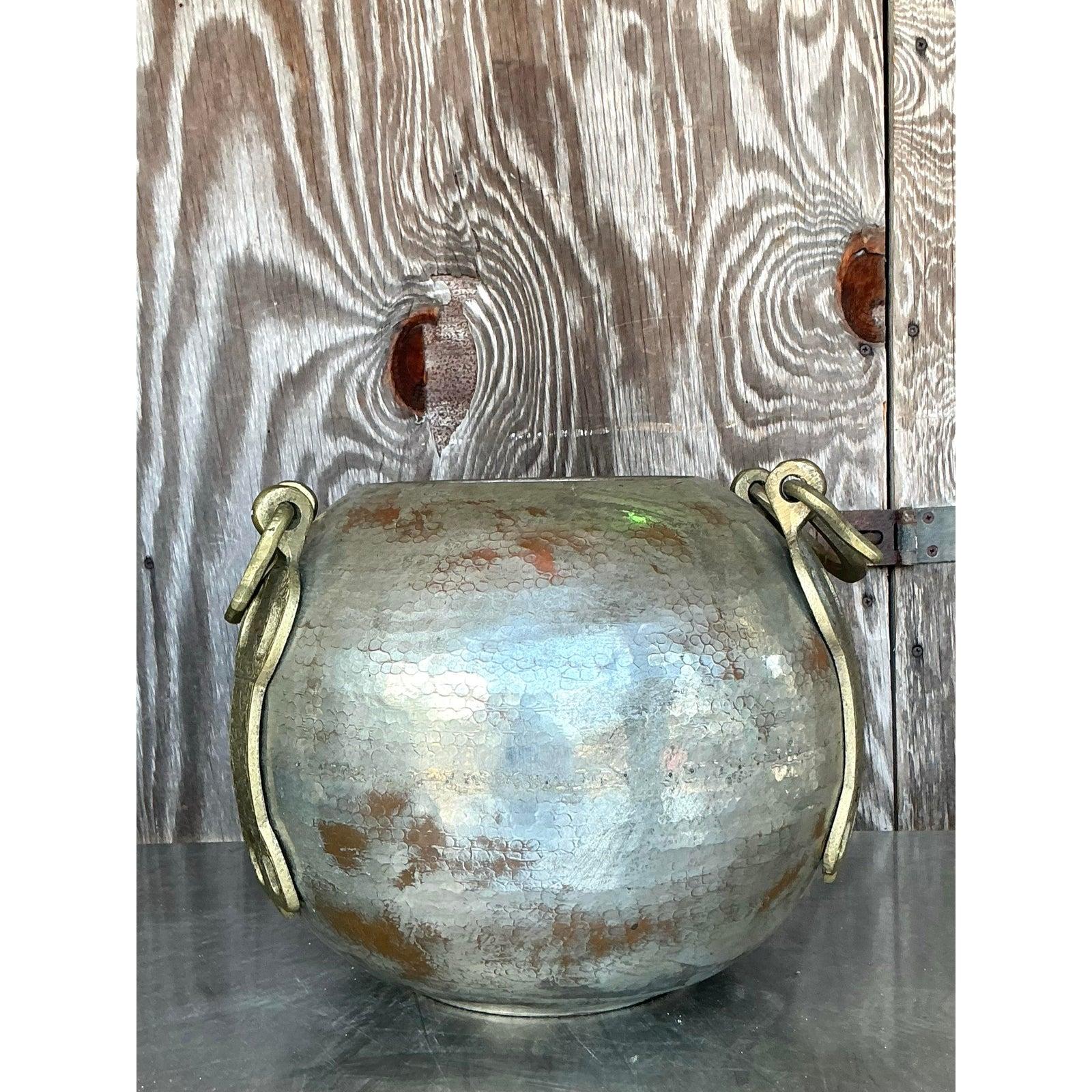 Verströmen Sie weltlichen Charme mit dieser bezaubernden Vase aus gehämmertem Kupfer und Messing im Boho-Stil. Ihre runde Form und der sorgfältig von Hand gehämmerte Kupferkorpus zeugen von außergewöhnlicher Handwerkskunst und reflektieren das Licht