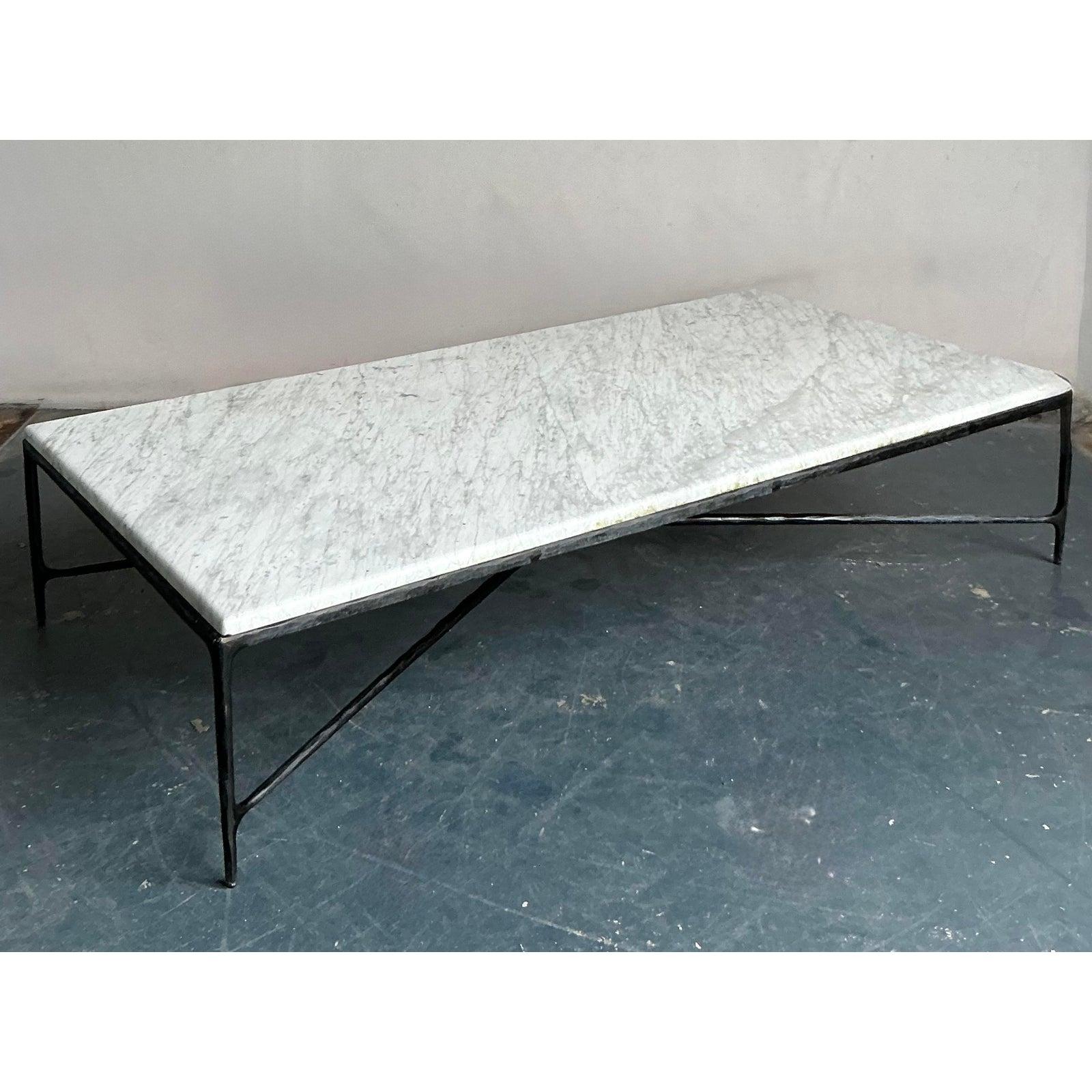 This unique vintage coffee table is a captivating study in contrasts, blending the raw, textural appeal of its handcrafted hammered iron base with the timeless elegance of a solid marble slab top. Evoking the free-spirited essence of 1970s boho chic