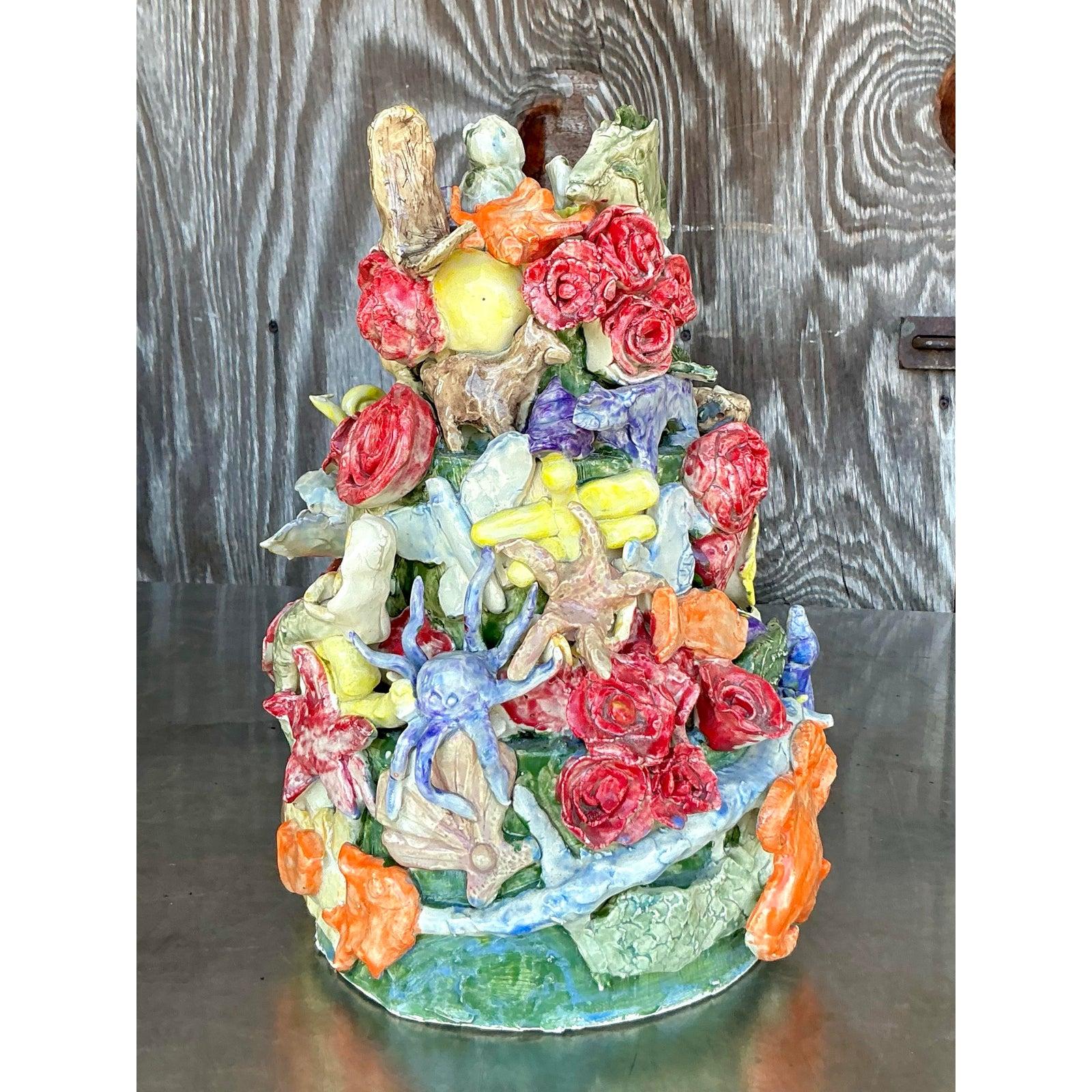 Abbraccia un fascino vibrante e artigianale con questa scultura totem in ceramica vintage unica nel suo genere. Abilmente costruito a mano, questo pezzo fantasioso presenta un'affascinante composizione densamente stratificata che sembra fondere
