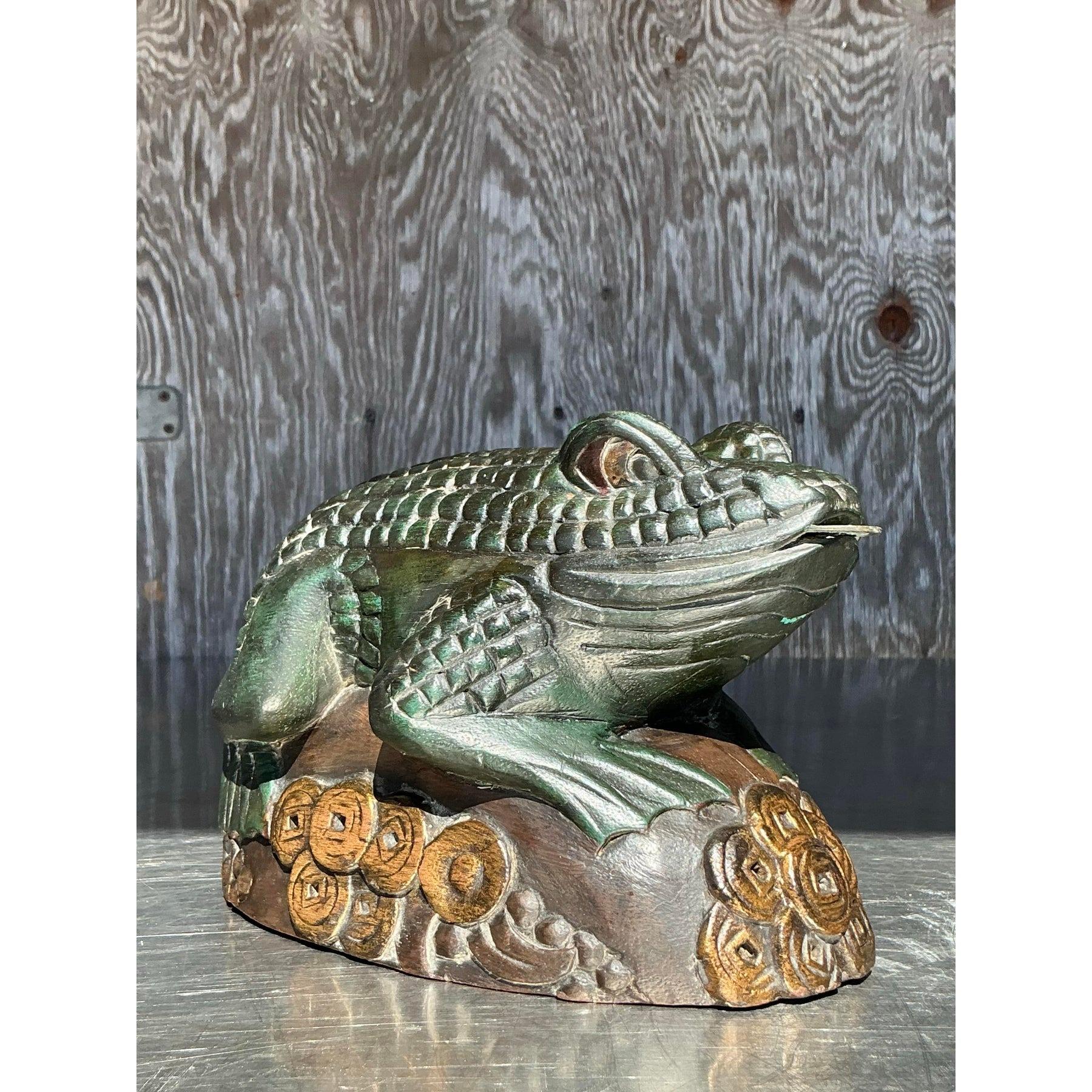 Aggiungi un tocco stravagante al tuo arredamento con questa rana vintage boho intagliata a mano. Realizzato con dettagli intricati, questo incantevole pezzo presenta una texture realistica e un design unico, appollaiato su una base ornata da motivi