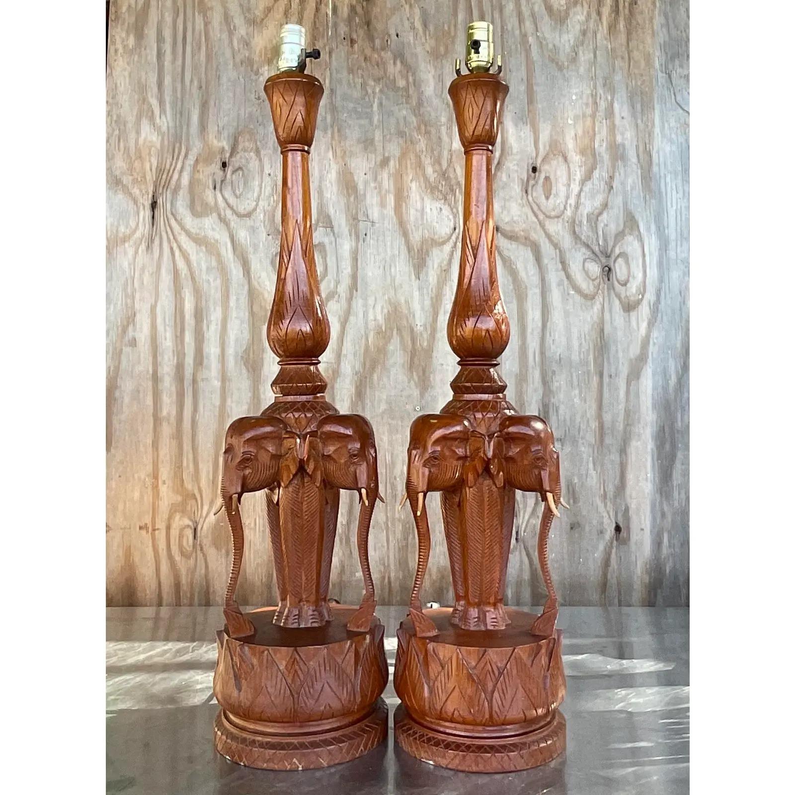 An incredible pair of hand carved table lamps. They highly coveted trio of elephants with all their tusks intact! A rare find. Acquired from a Palm Beach estate.

The lamps are in great vintage condition. Minor scuffs an blemishes appropriate to