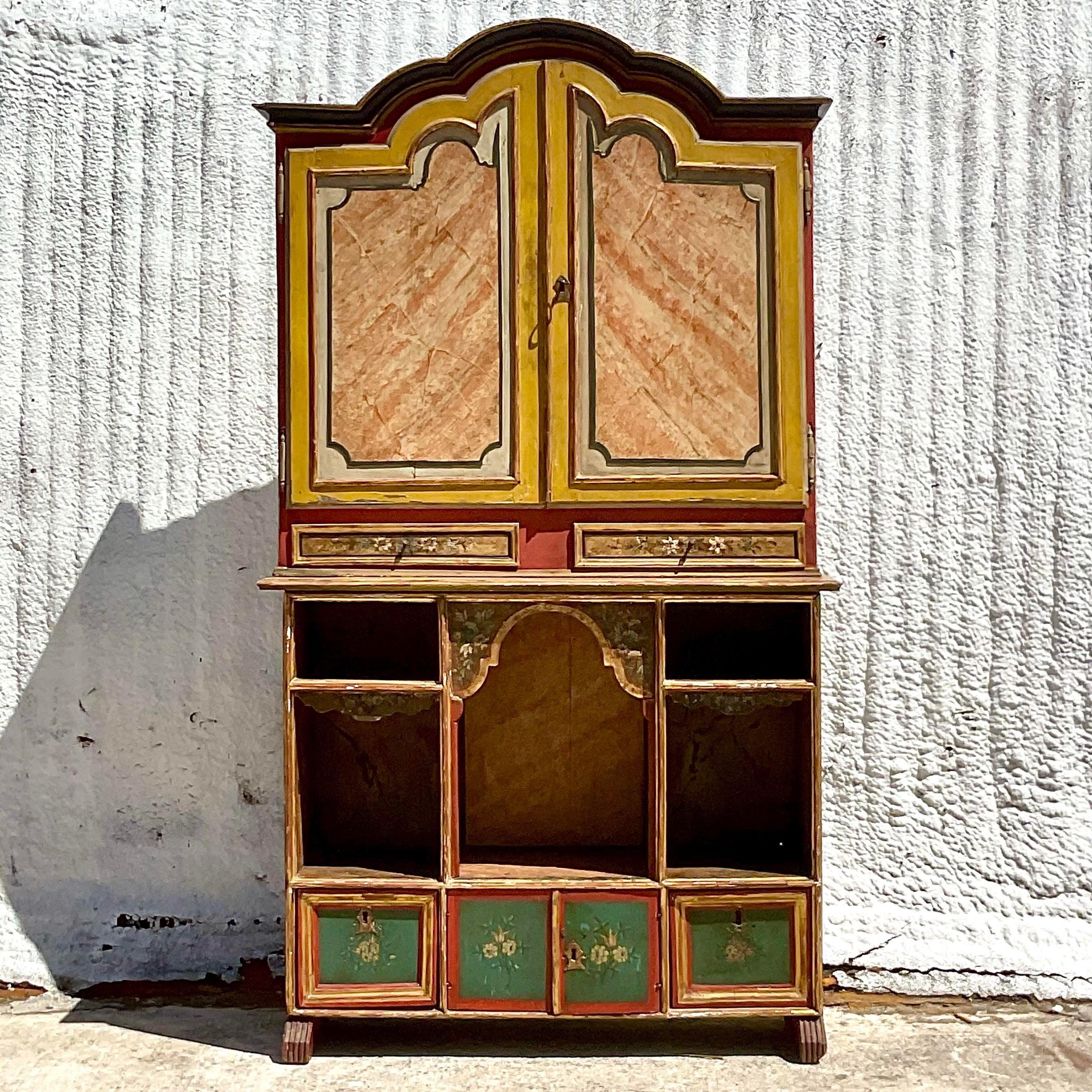 A fabulous vintage Boho storage cabinet. Beautiful hand painted details with lots of great storage below. The top and bottom separate for easy movement. Acquired from a Palm Beach estate.