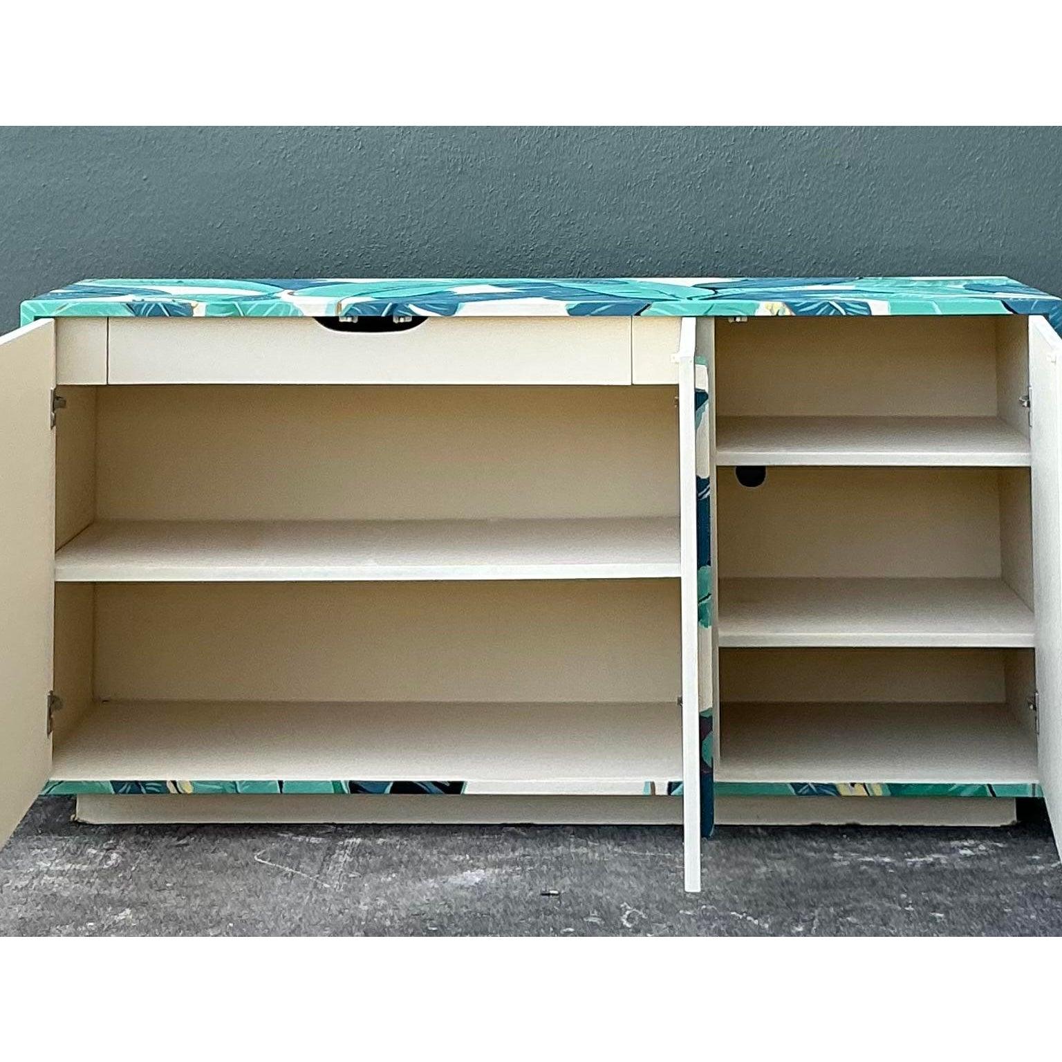 Retrouvez le glamour emblématique de l'hôtel Beverly Hills et l'énergie vibrante de Palm Beach avec cette spectaculaire crédence vintage peinte à la main. Chef-d'œuvre du style Hollywood Regency, cette pièce est enveloppée d'un luxuriant motif de