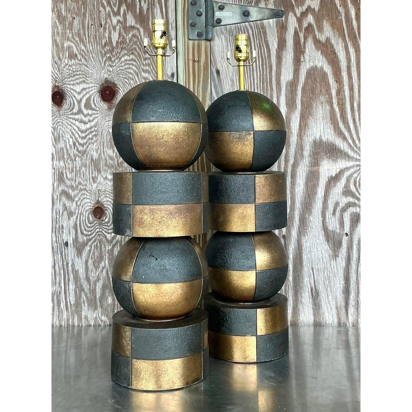 Illuminez votre espace avec un panache vintage indéniable grâce à cette paire de lampes Harlequin saisissante. Leur design audacieux et sculptural présente un jeu captivant de formes géométriques empilées - sphères et cylindres - dramatiquement mis
